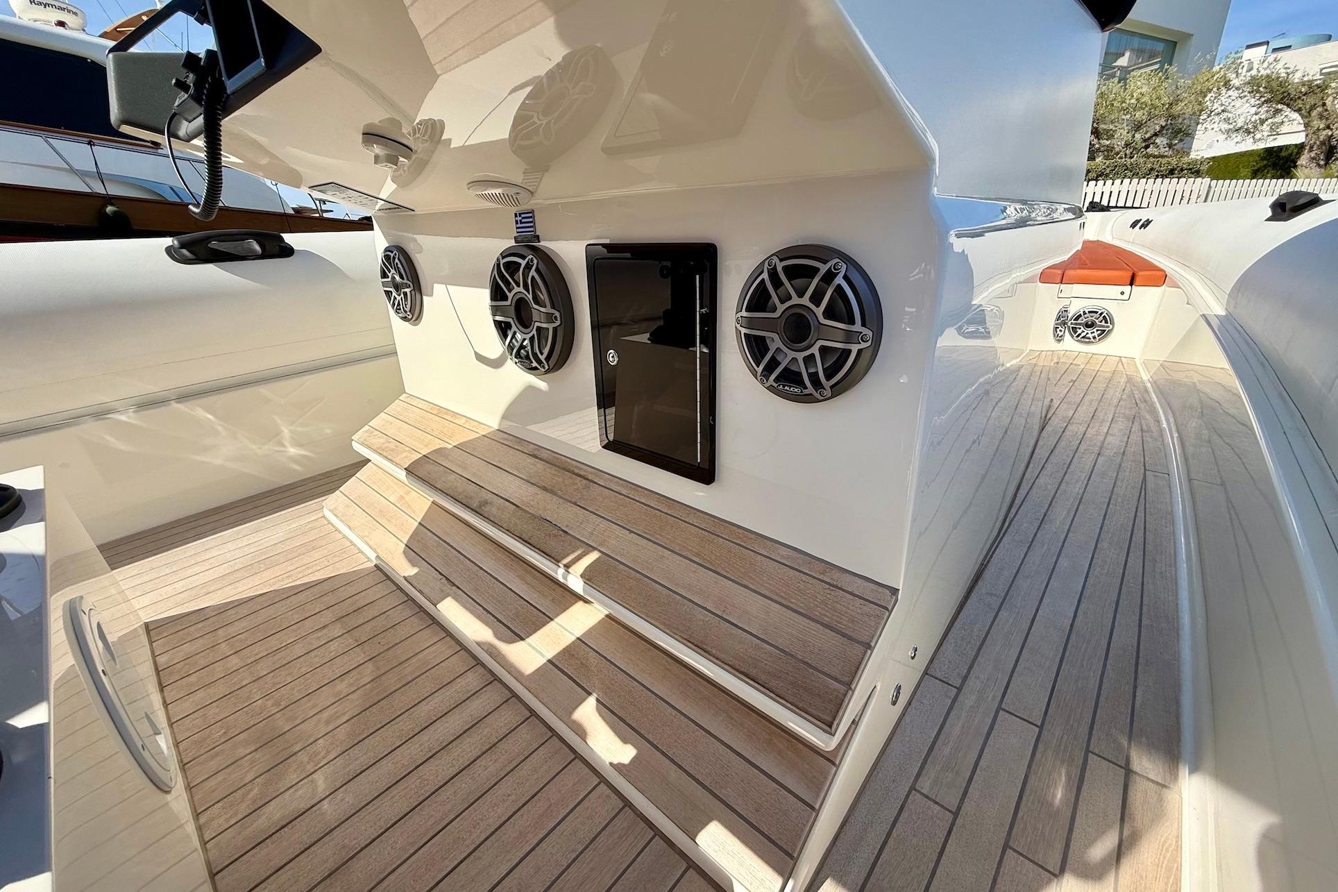 2025 Technohull 38 Grand Sport interior with speakers and wooden flooring.