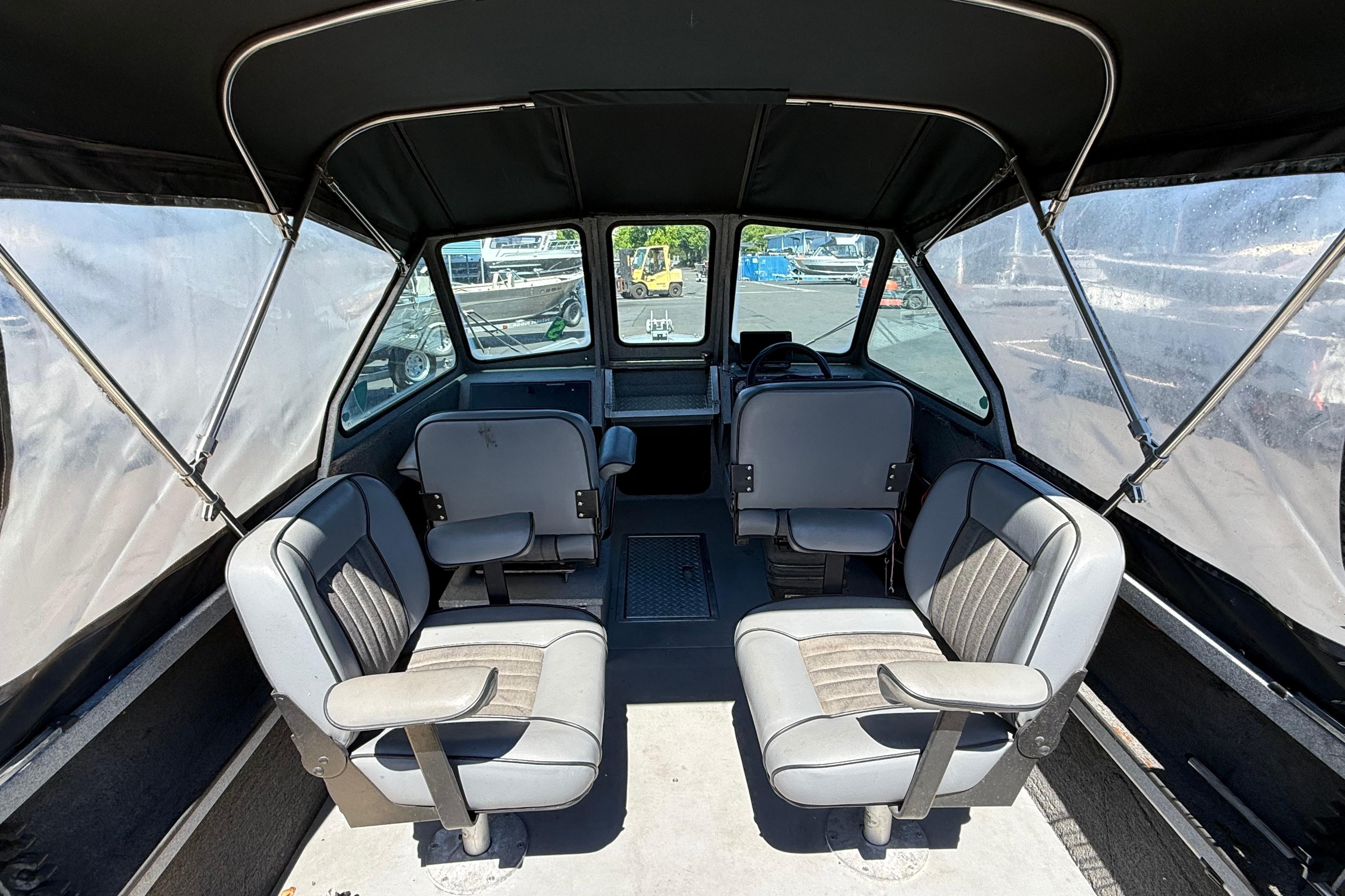 Interior of a 2004 Alumaweld Intruder Outboard 20 boat with seating and canopy.