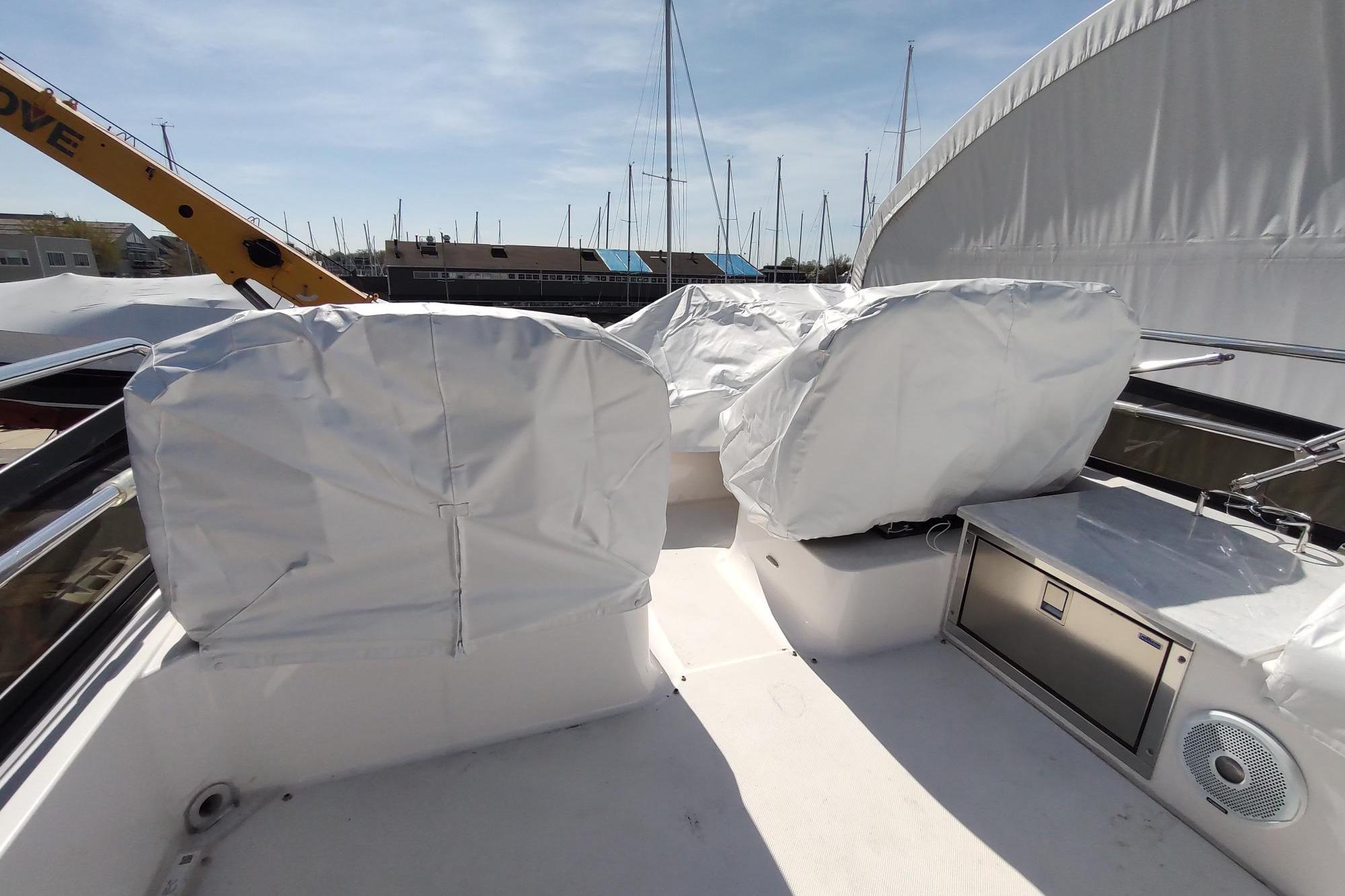 Covered seating area on a 2021 Regal 42 Fly yacht, docked with marina view.
