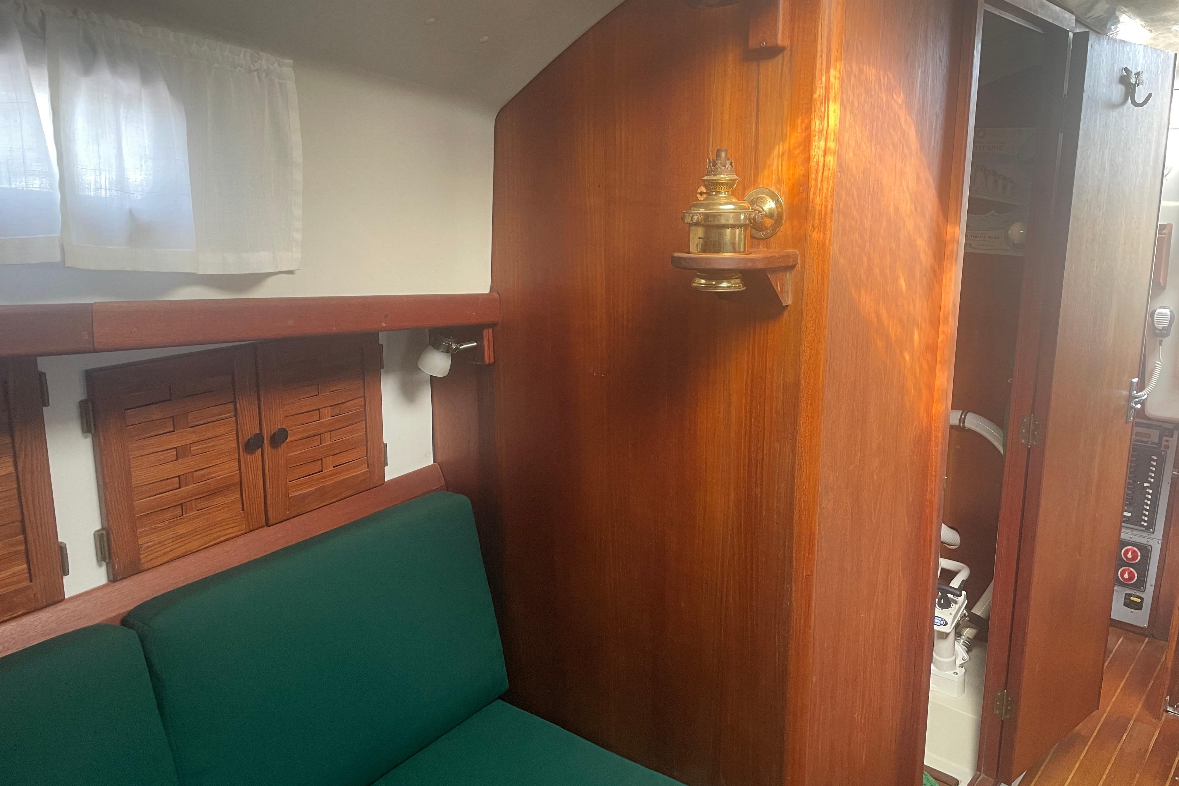 Interior of 1981 Nonsuch 30 Classic sailboat with wooden cabinetry and green seating.