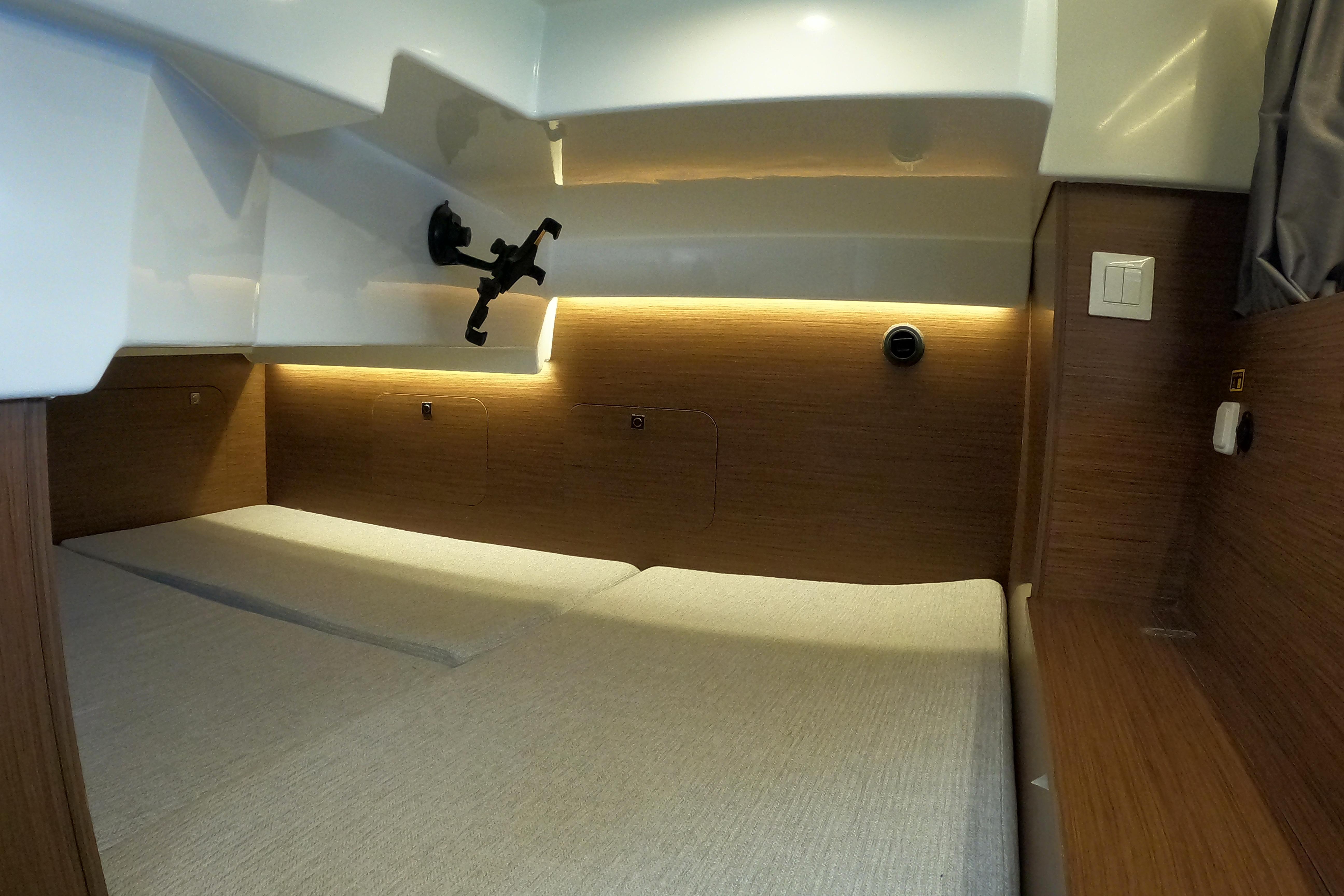 Interior cabin of 2022 Jeanneau NC Sport 895 with modern lighting and wood finish.