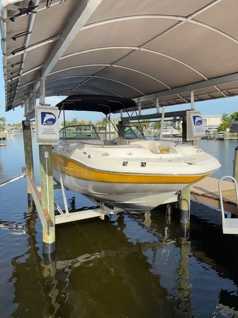 A 2008 Hurricane Sun Deck 24 is positioned on a boat lift above the water.