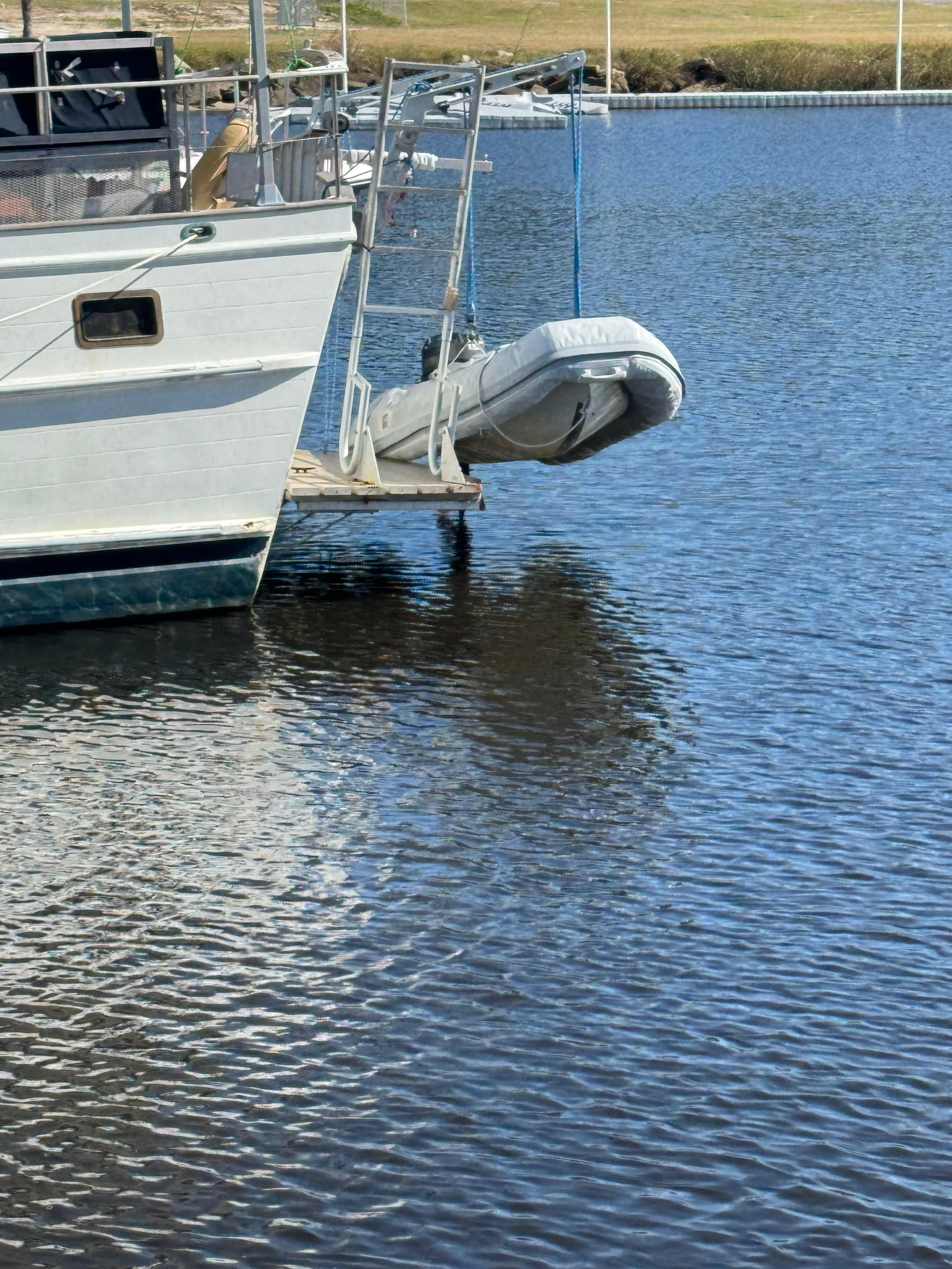 1983 Island Trader Motor Sailor with dinghy on calm water.