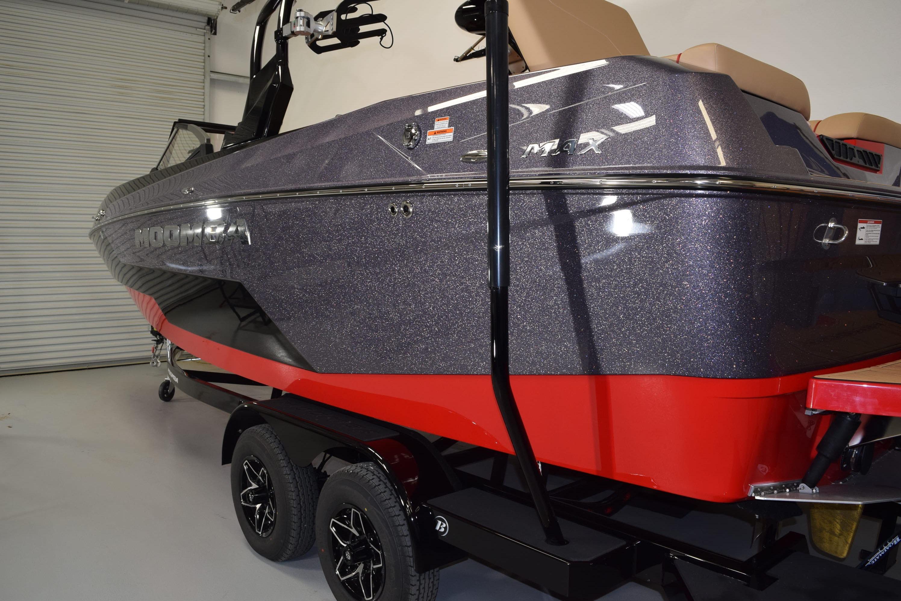 2026 Moomba Max boat with sleek design, red and gray color scheme, on trailer.