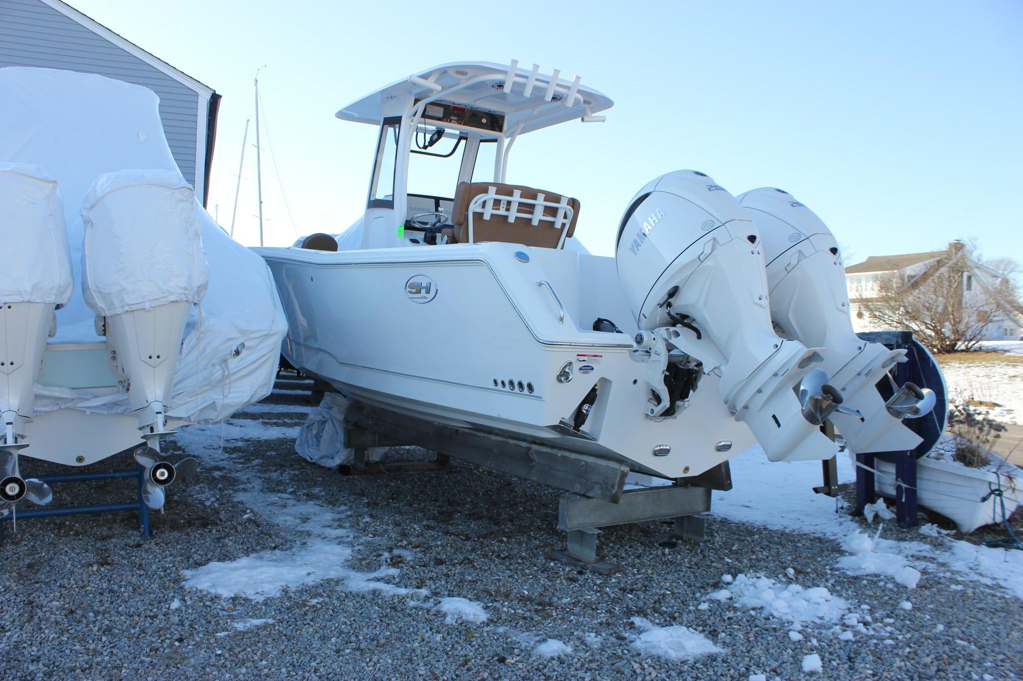 2026 Sea Hunt Gamefish 25 boat with dual Yamaha engines on a snowy lot.