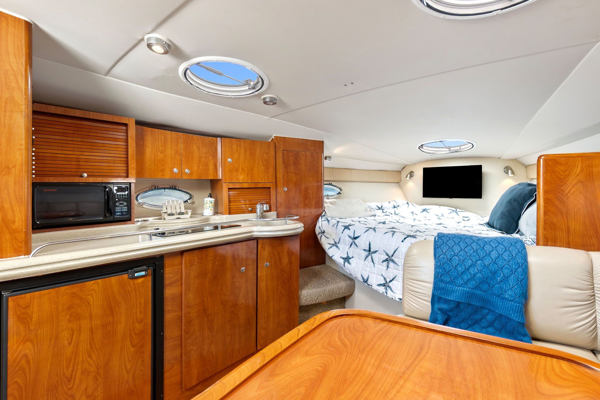 Interior of a 2007 Larson Cabrio 330 with kitchen, bed, and dining table.