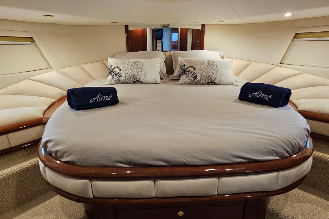 Luxurious bedroom interior of 2001 Fairline Squadron 52 yacht with elegant bedding.