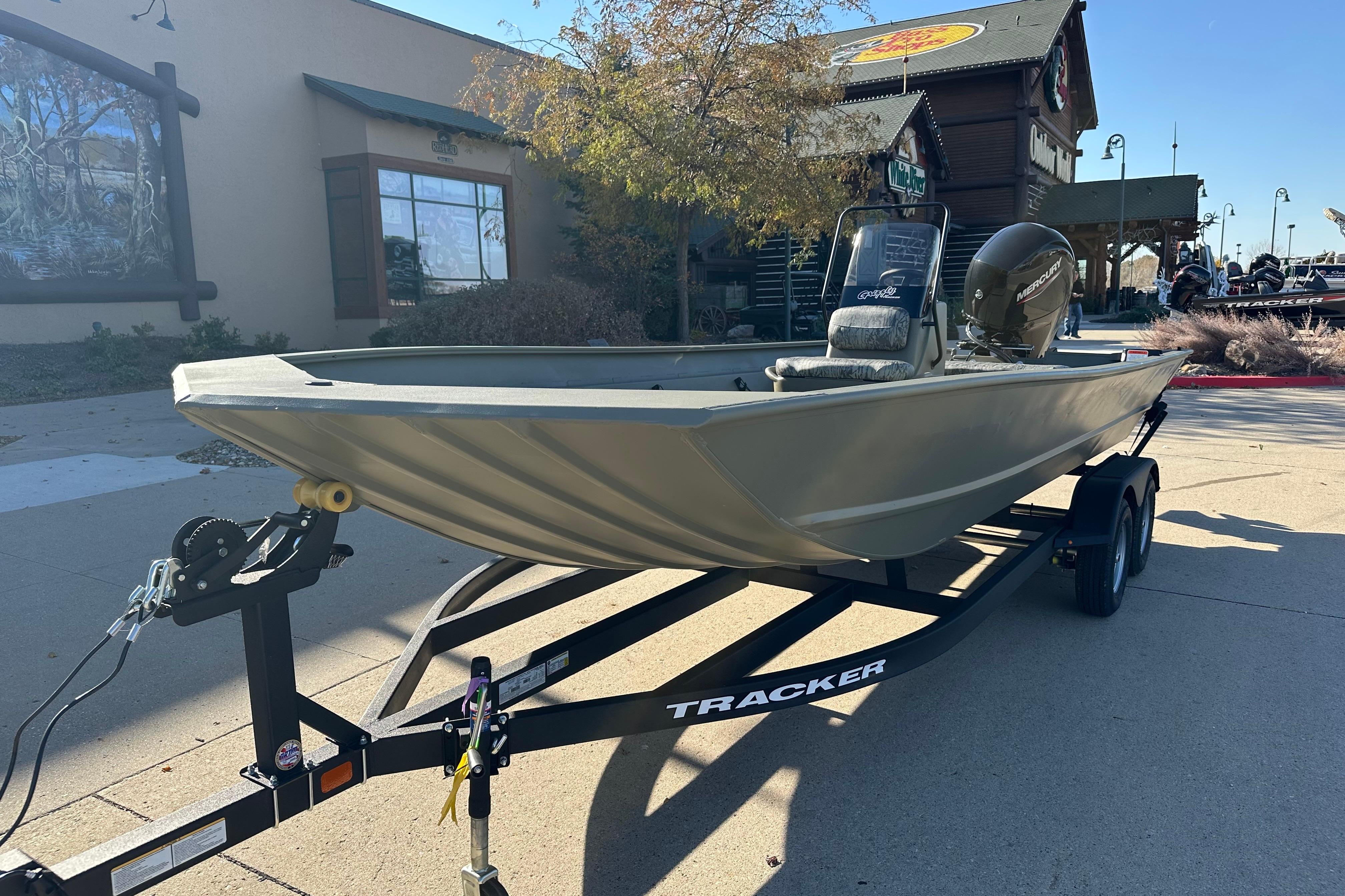 2026 Tracker Grizzly 2072 CC boat on trailer, parked outdoors near a building.