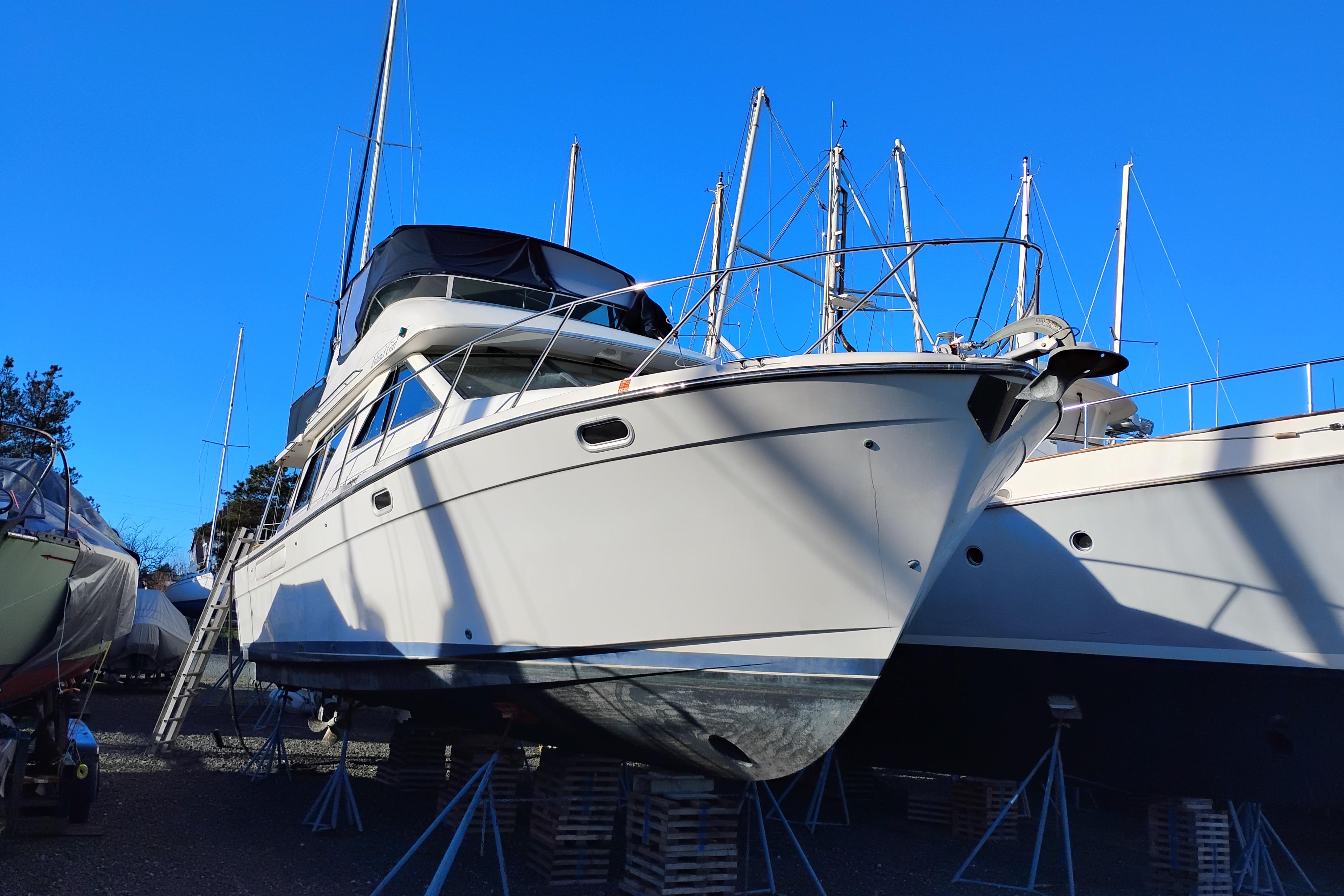 2000 Bayliner 3988 Command Bridge Motoryacht on stands under clear blue sky.