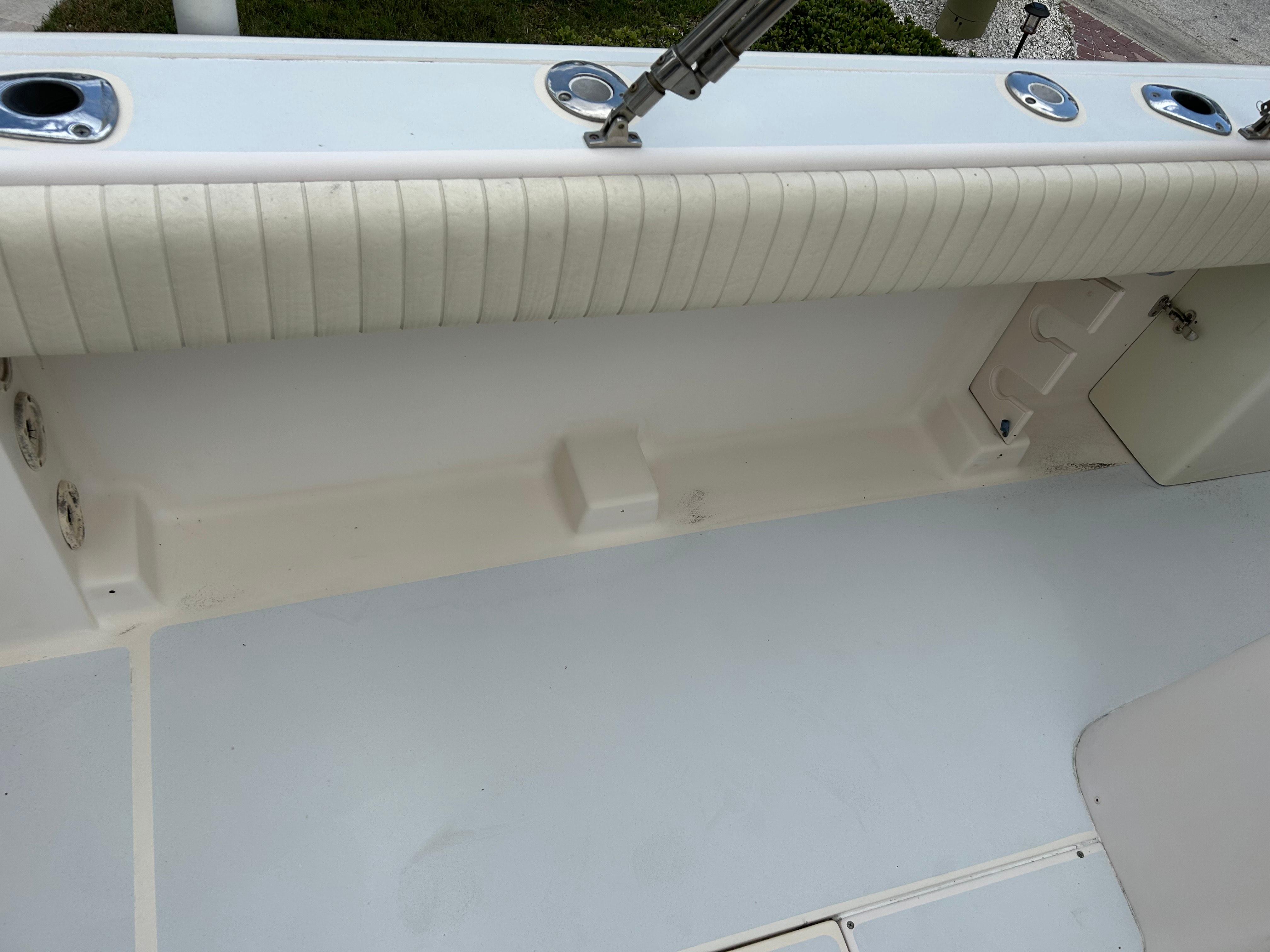2002 Grady-White 306 Bimini boat interior, featuring rod holders and cushioned side panel.