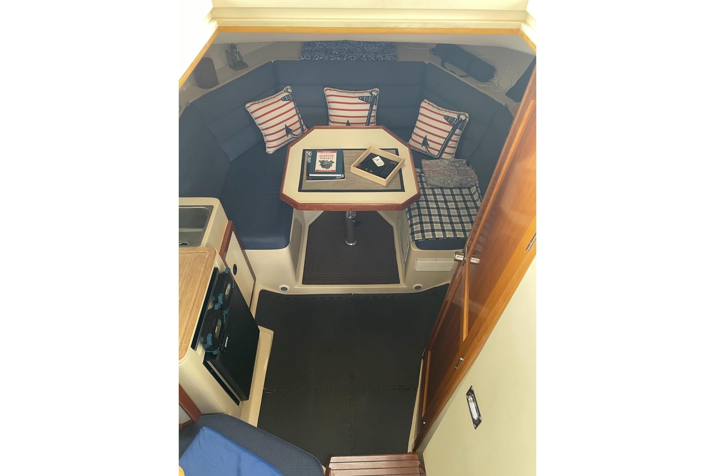 Interior of 2003 Albin 28 Tournament Express with cozy seating and nautical decor.