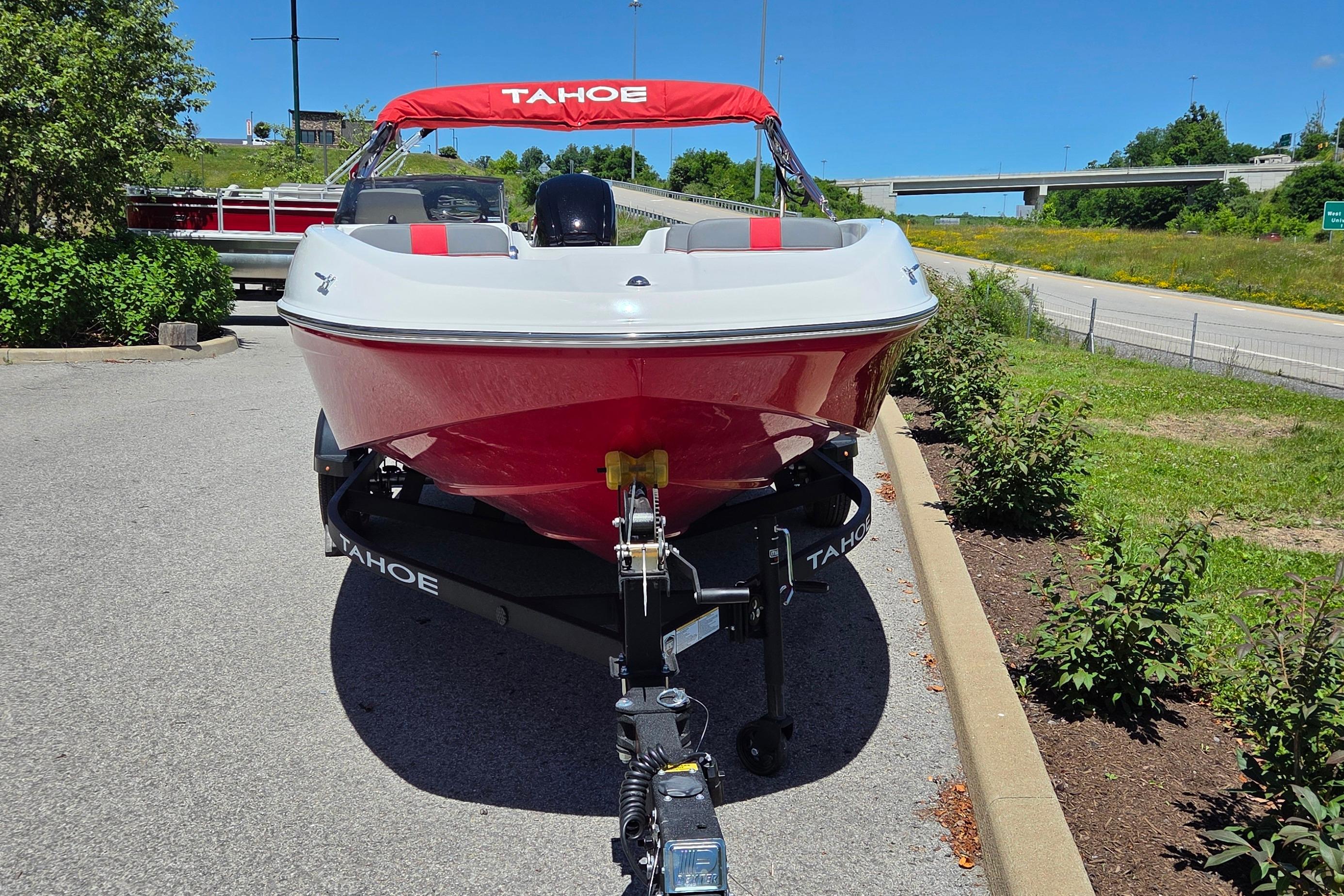 2026 Tahoe T16 boat on trailer, red and white design, parked outdoors on sunny day.