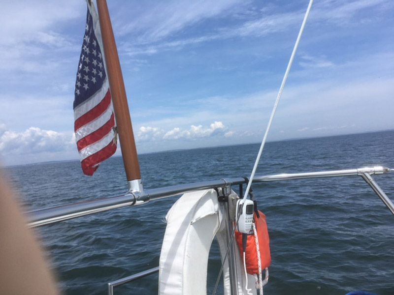 1975 O'Day Sloop sailing with American flag on open sea.