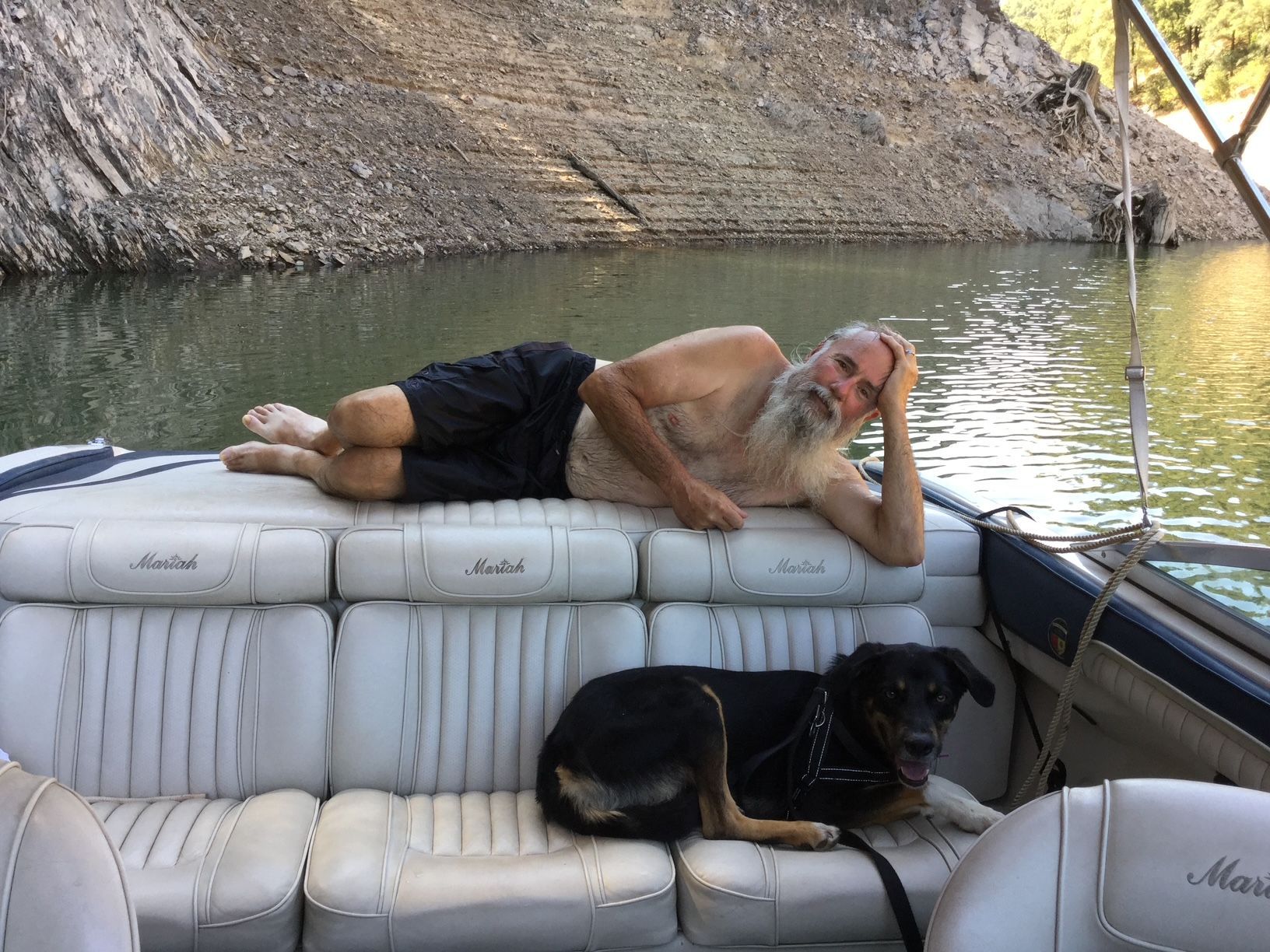 Man and dog relaxing on a 1996 Mariah Talari boat.