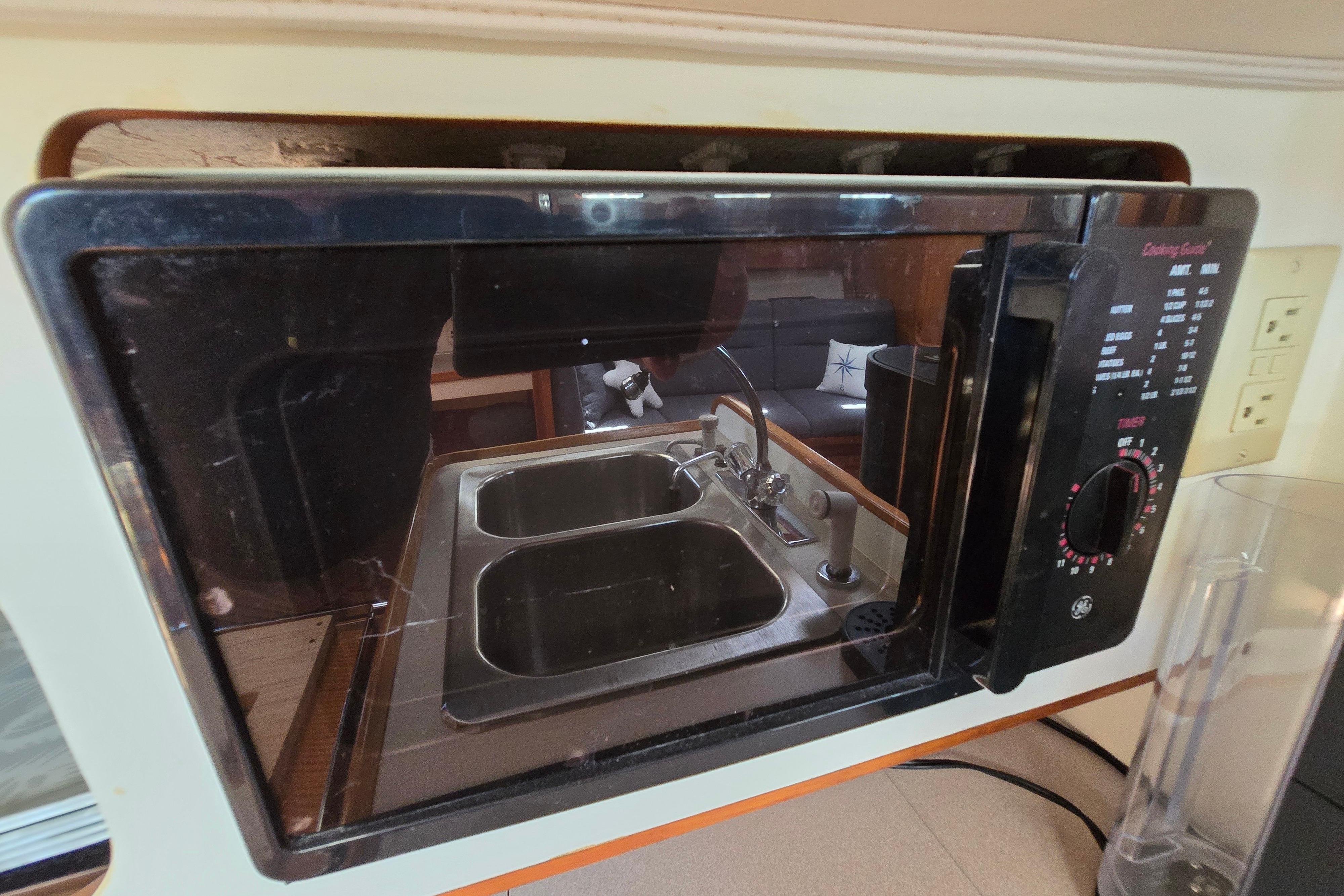 Microwave reflection showing a kitchen sink inside a 1993 Caliber 35 boat.
