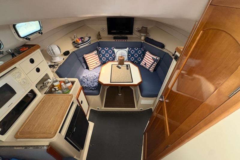 Interior of 2003 Albin 28 Tournament Express with cozy seating and compact kitchen area.