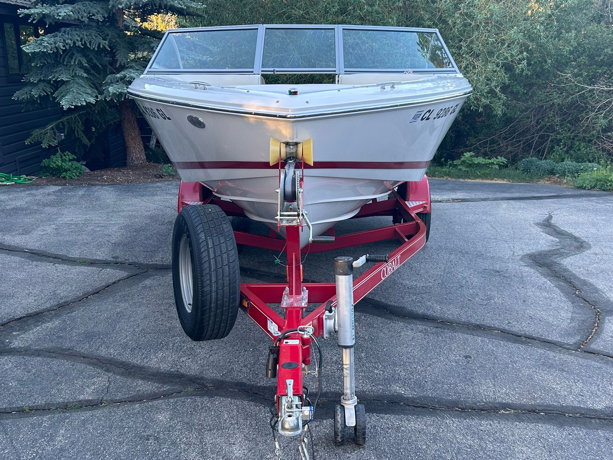 2012 Cobalt 200 boat on red trailer, parked on asphalt.