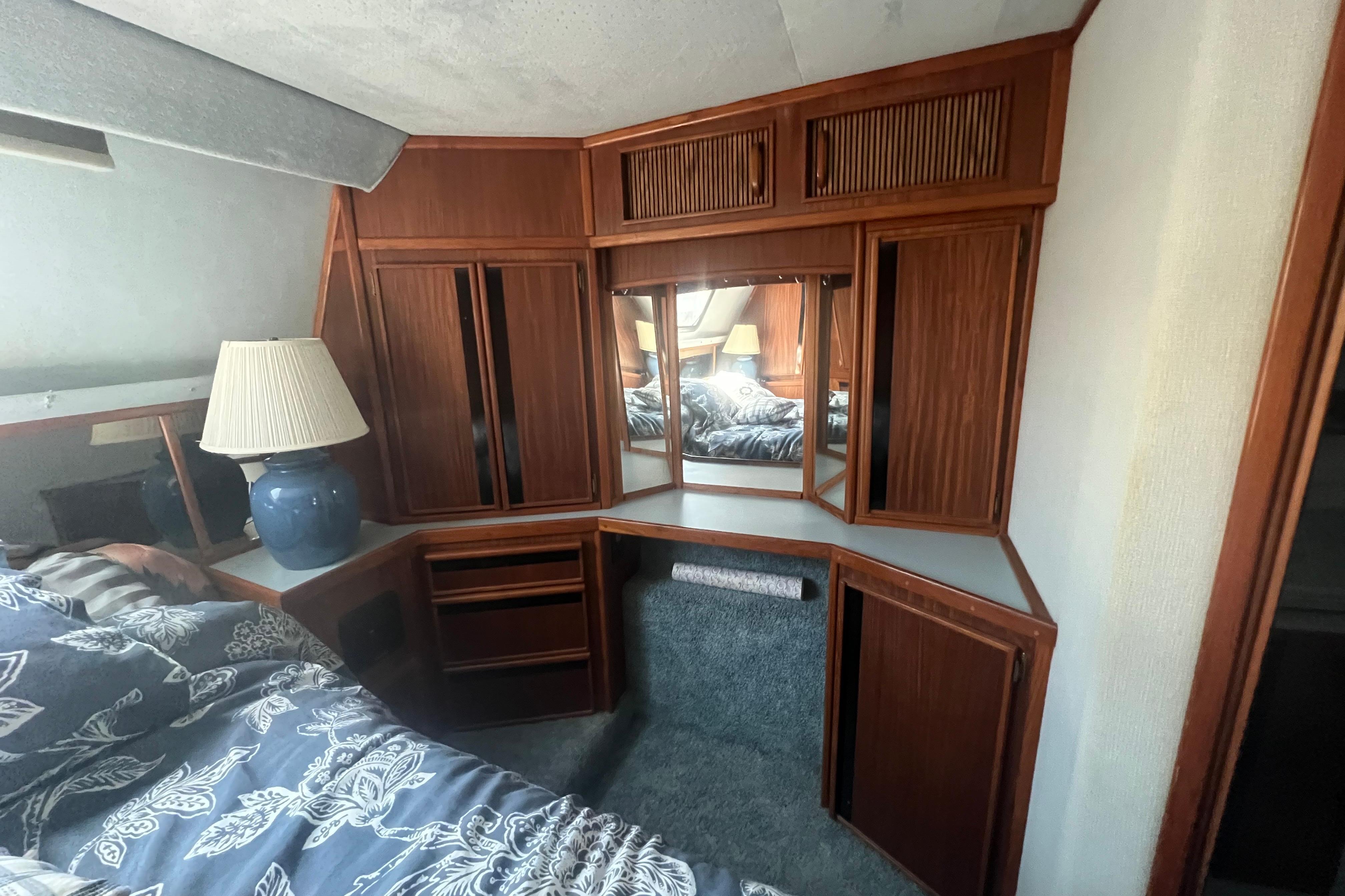 Interior of 1987 Sea Ray 410 Aft Cabin with wood cabinetry and a blue lamp.
