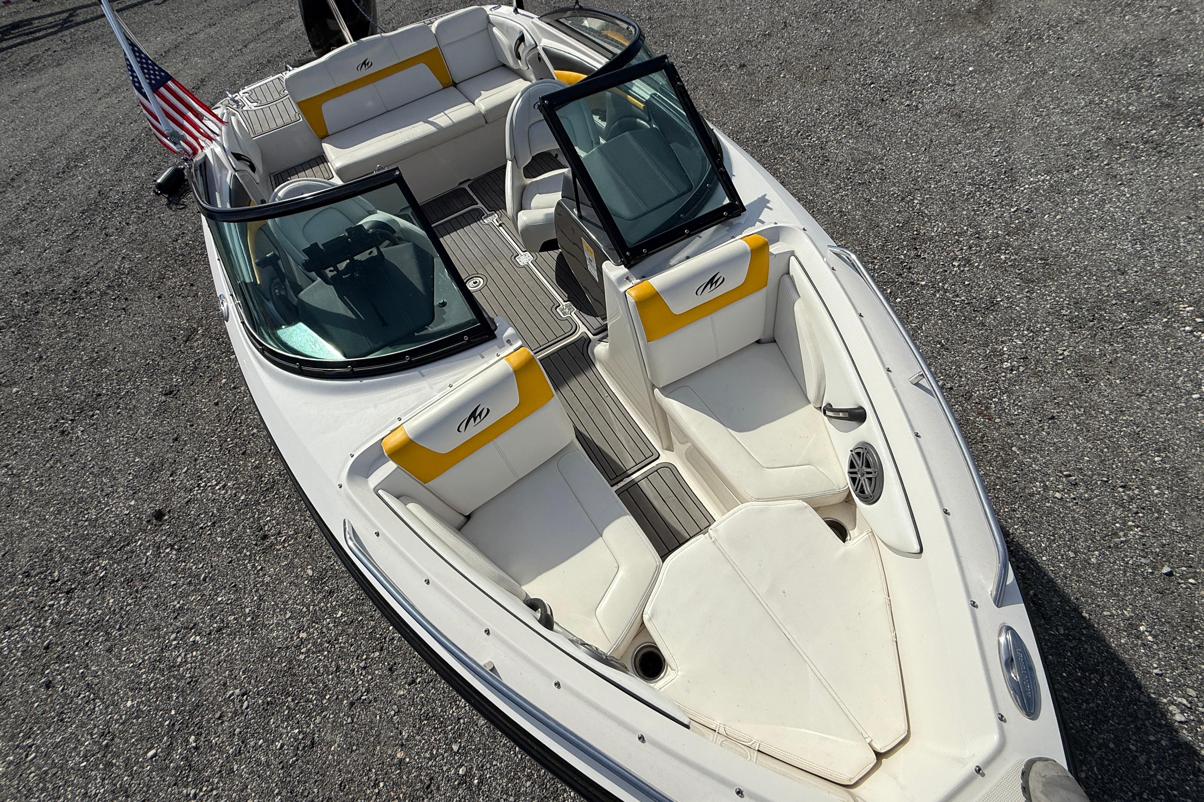2014 Monterey 197 Blackfin boat with white and yellow seating, American flag displayed.