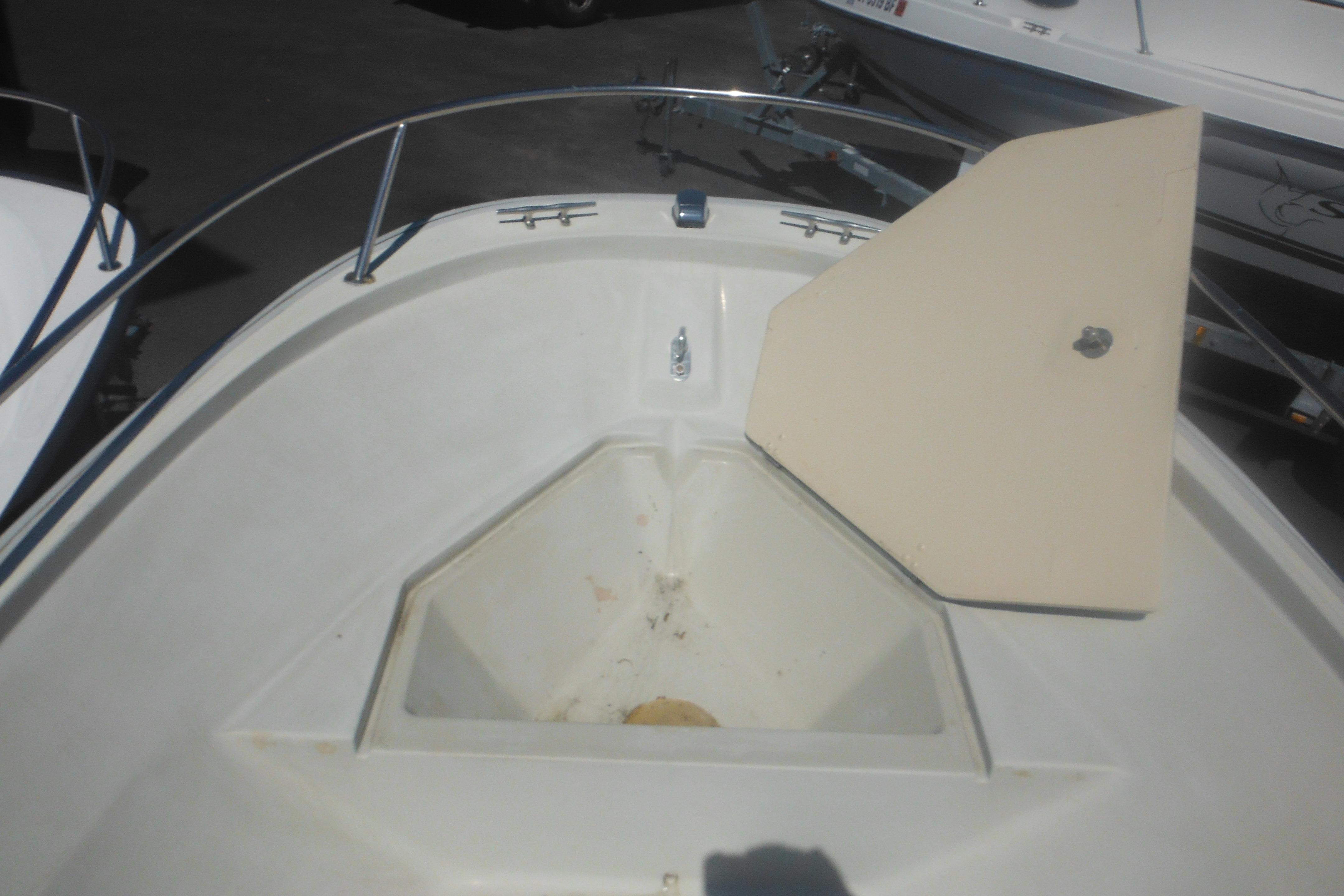 1991 Boston Whaler 16 SL boat bow with open storage compartment.