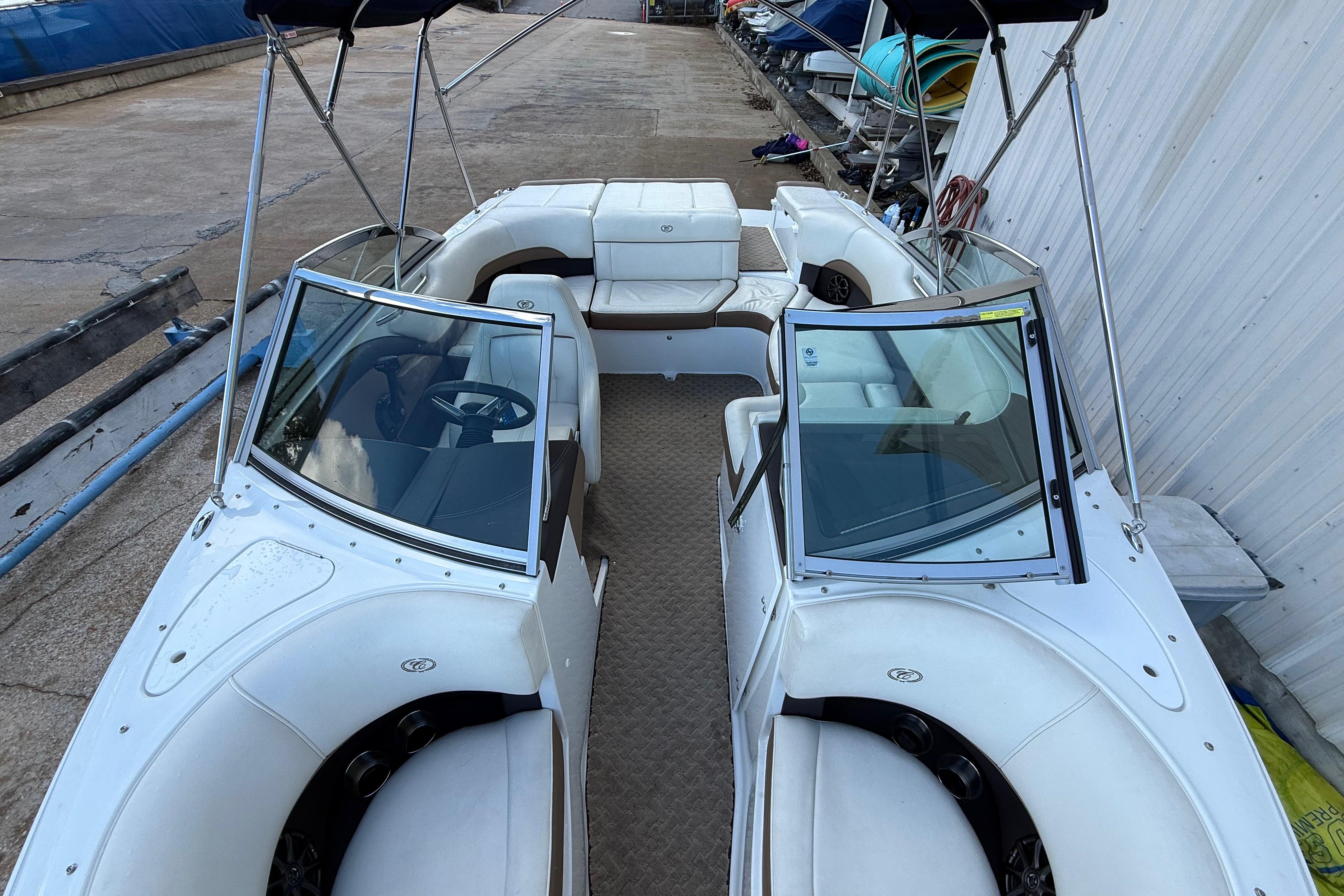 2015 Cobalt 200 boat with white seating and dual windshields, docked outdoors.