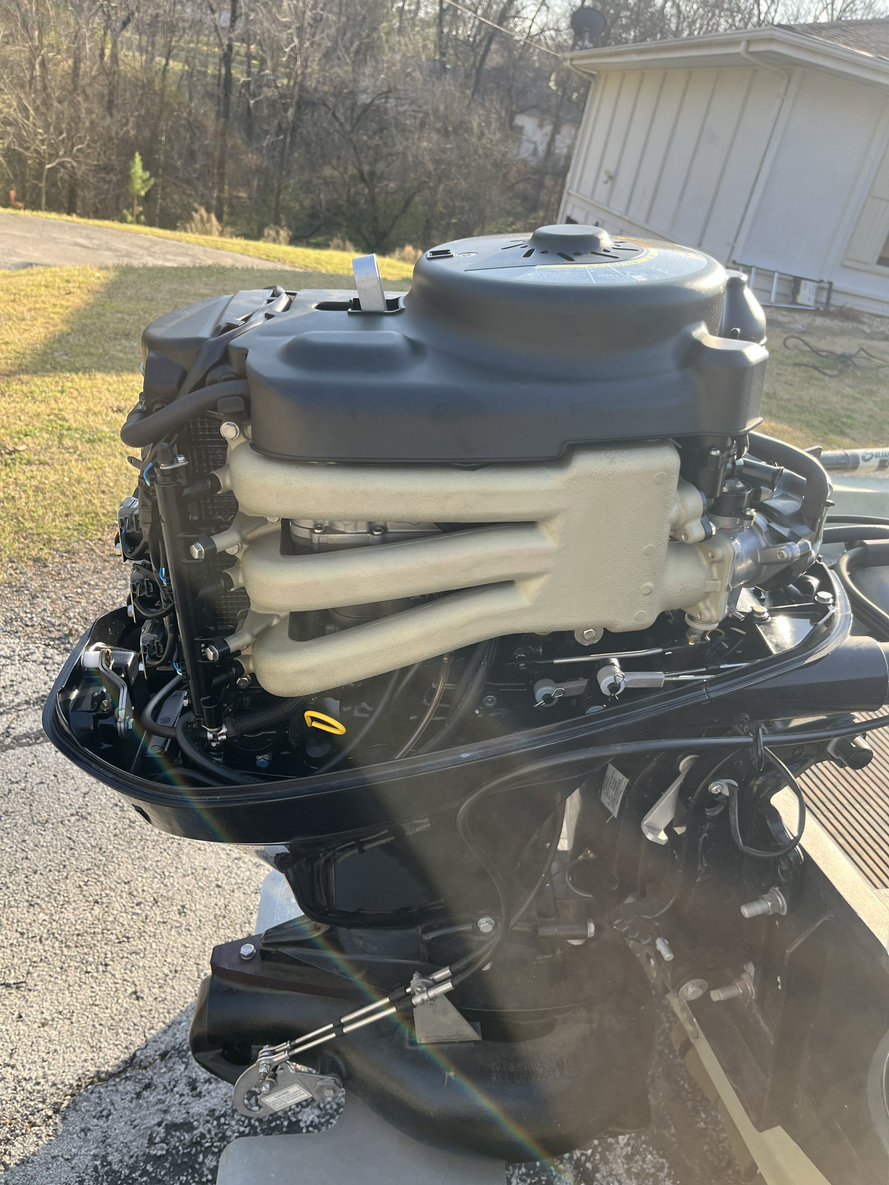 Outboard motor of a boat on a trailer, with a building in the background.