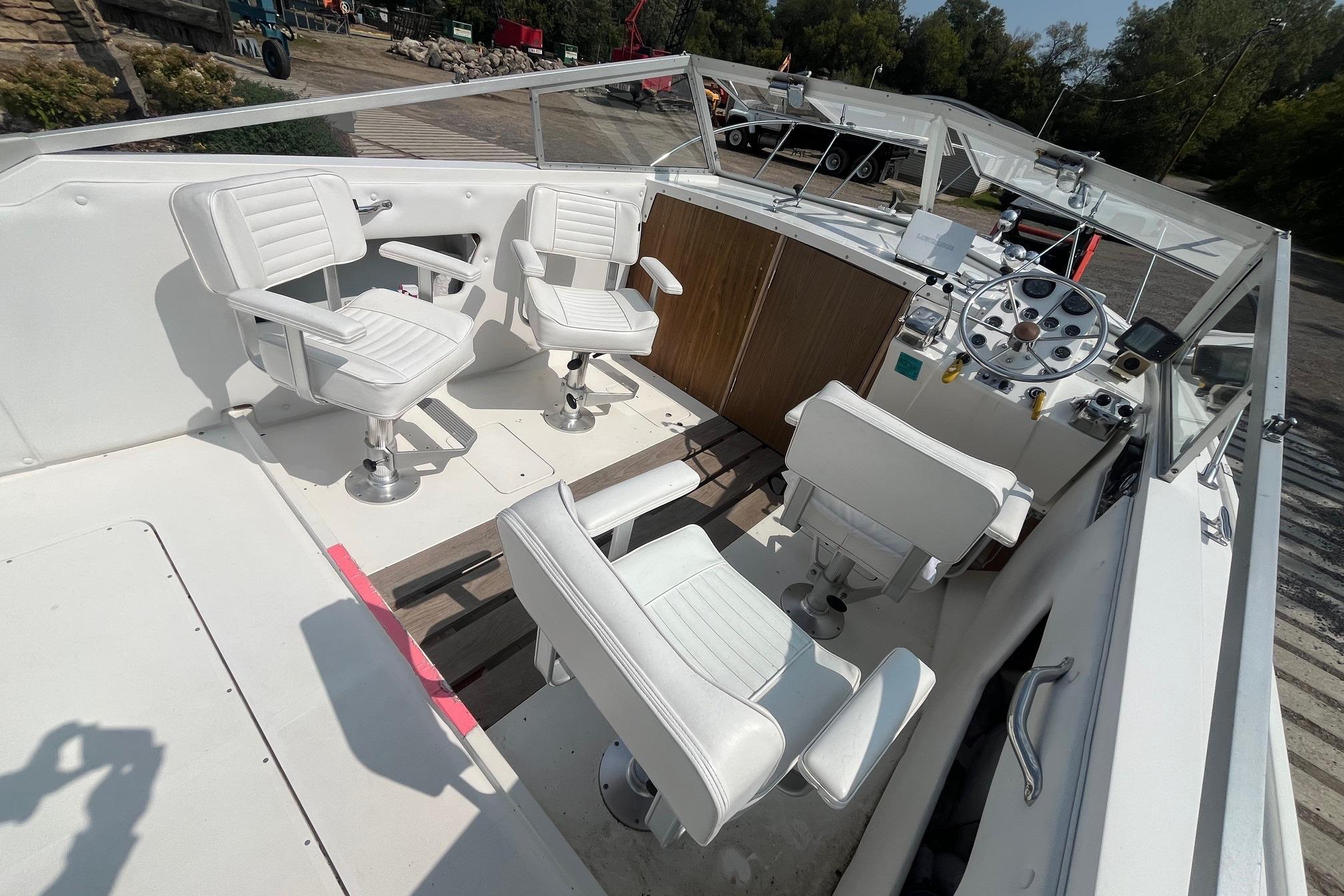 1975 Bertram 26 Moppie boat interior with white seating and control panel.