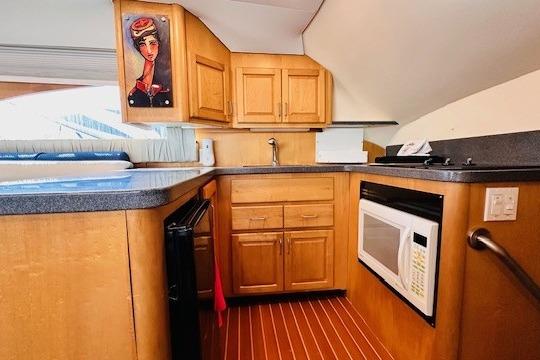 Kitchen area of 2001 Luhrs 40 Convertible boat with wood cabinets and modern appliances.