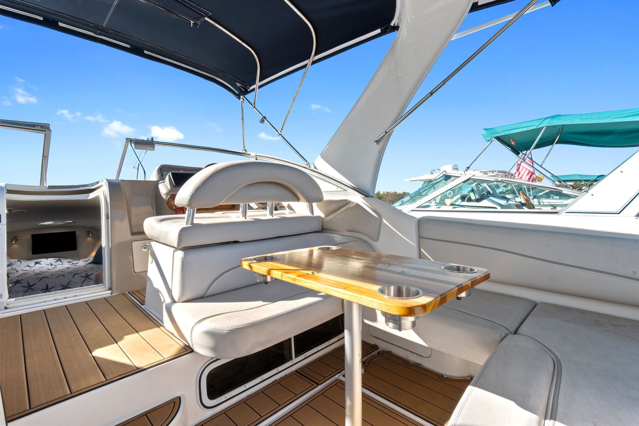 The image shows the cockpit of a 2007 Larson Cabrio 330 with a wooden table and white seating.