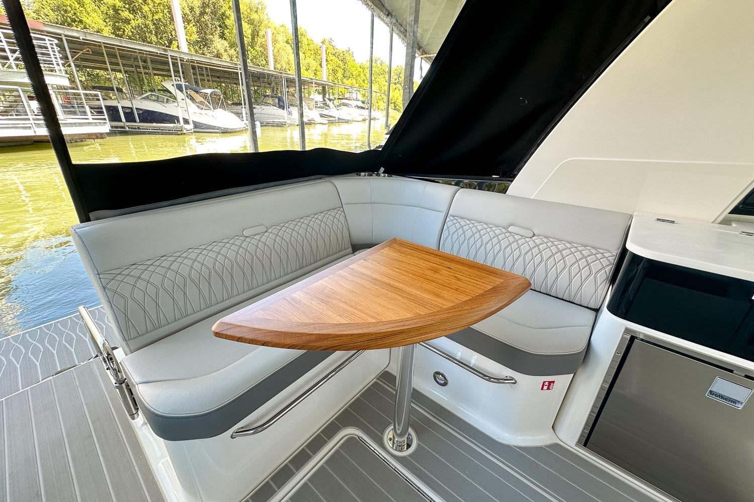 Luxurious seating area on 2025 Sea Ray Sundancer 370 yacht with elegant wooden table.