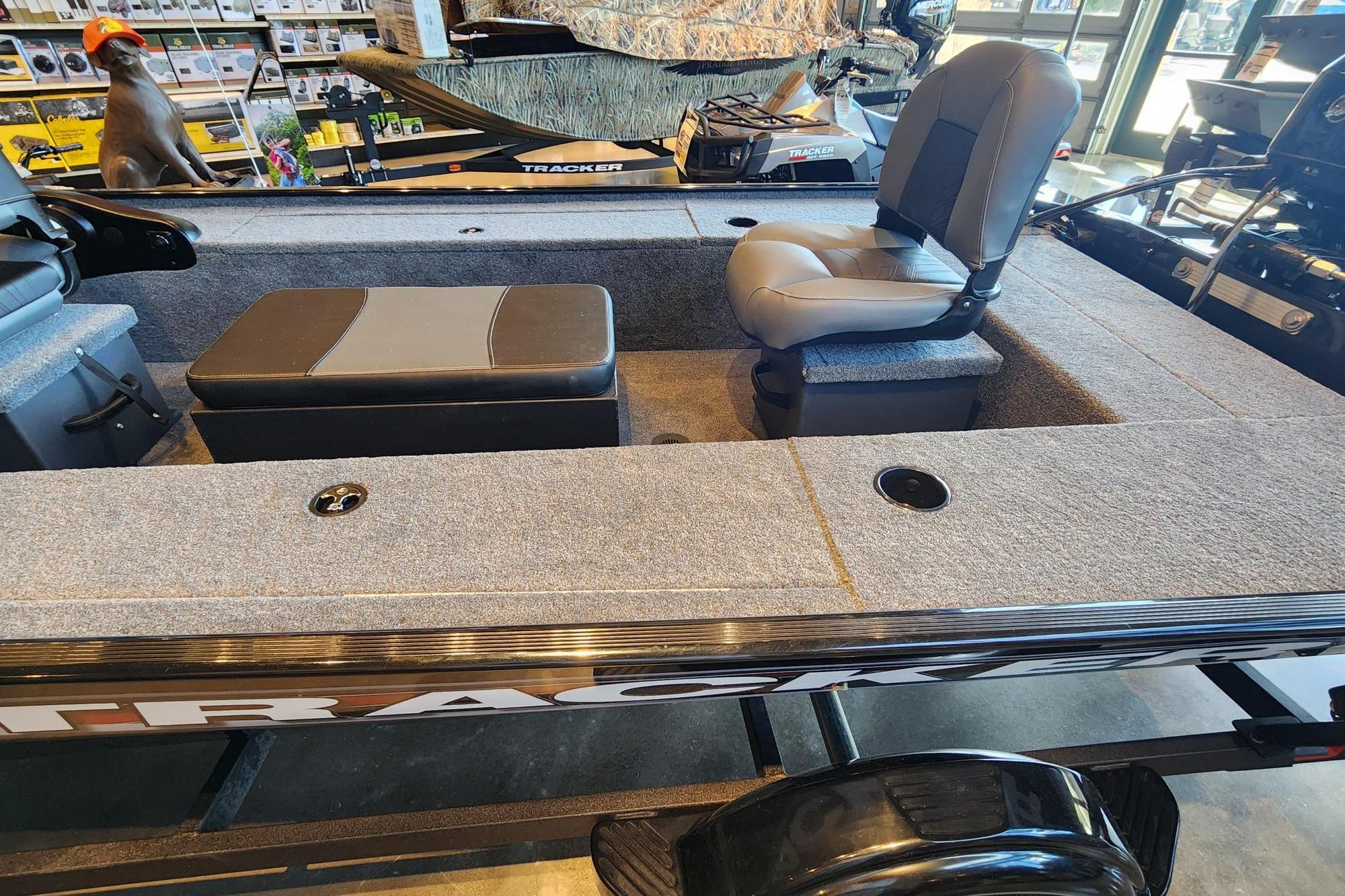 2026 Tracker Panfish 17 boat interior with seating and storage, displayed in a showroom.