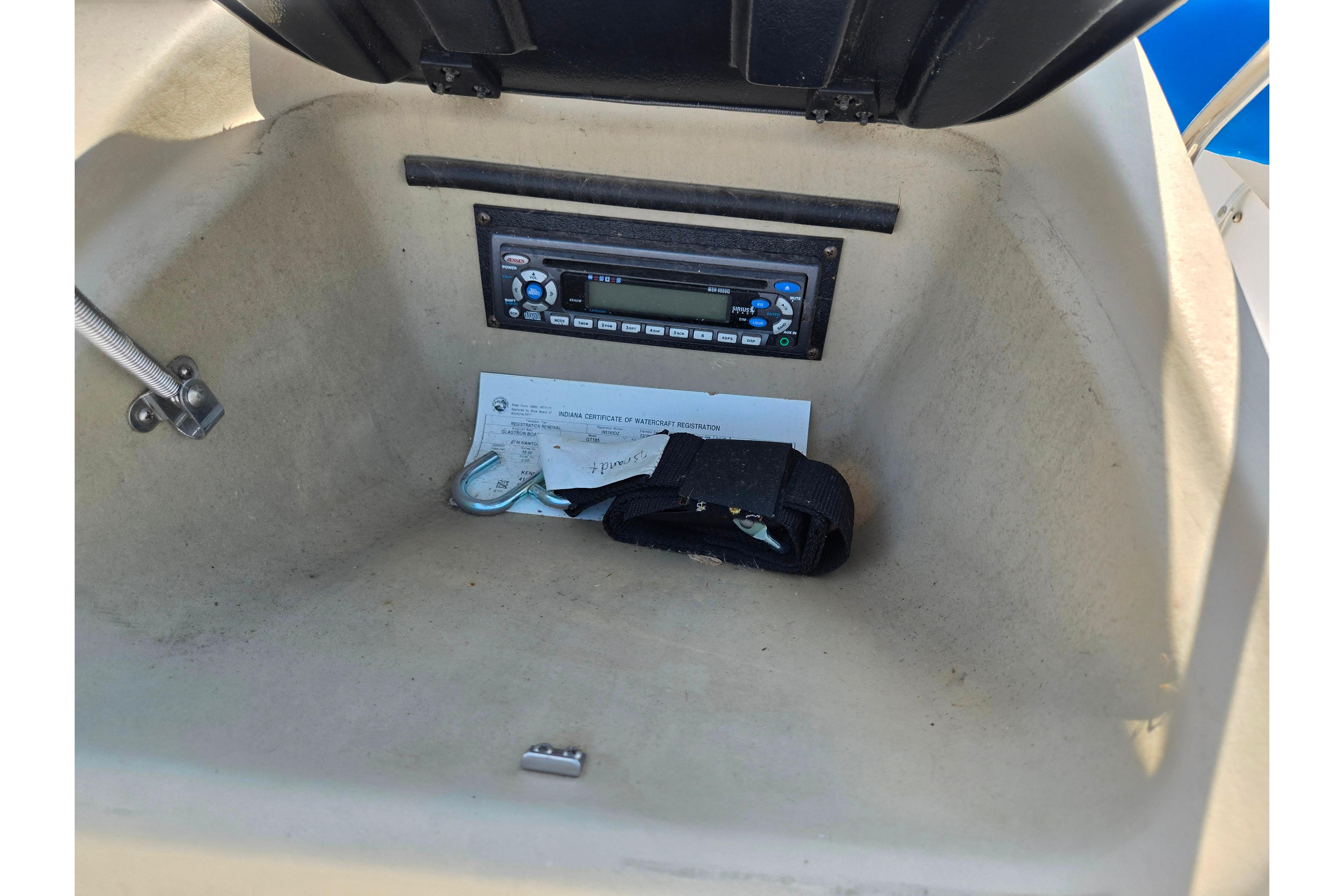 2007 Glastron GT 185 boat storage compartment with stereo and documents.
