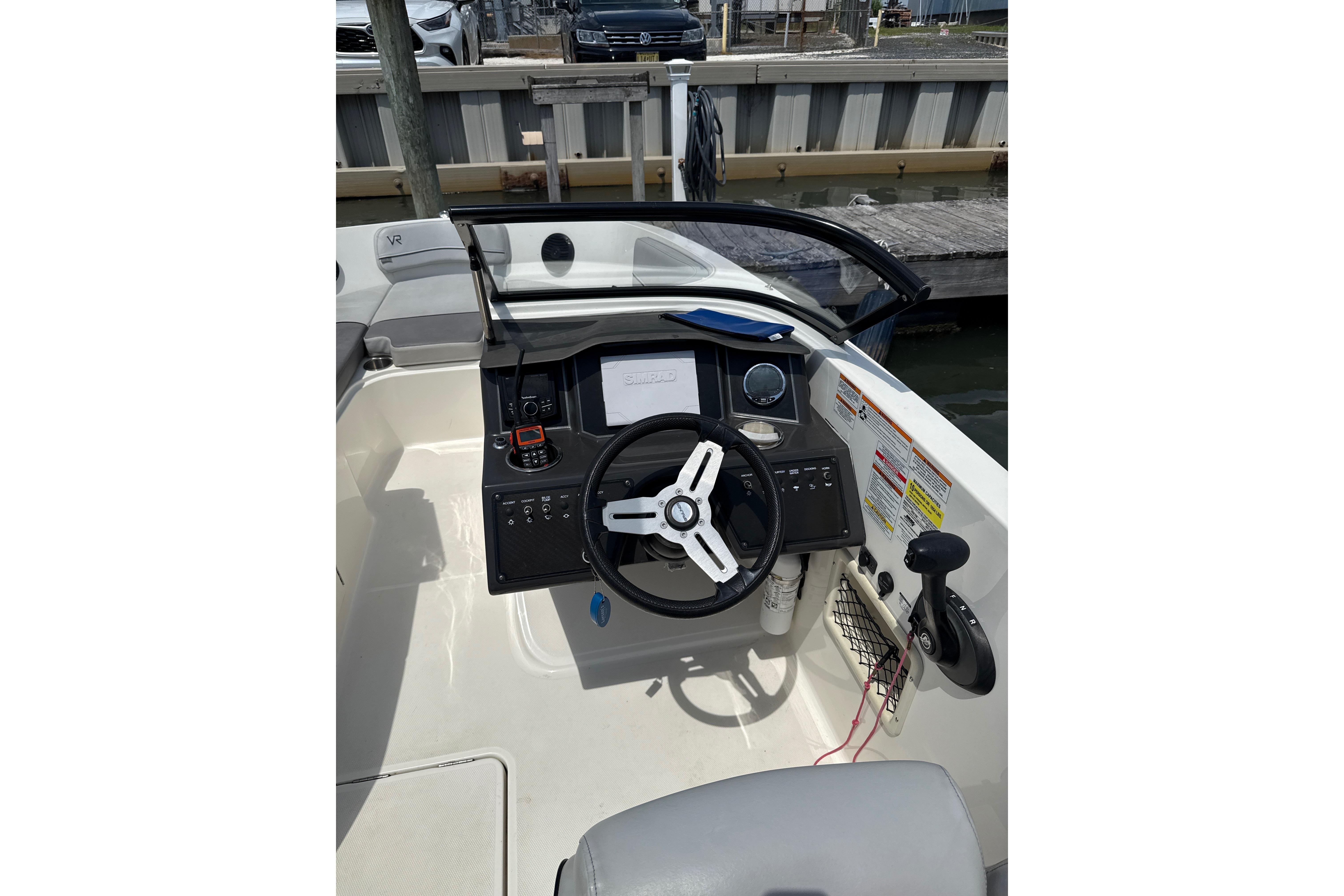 2023 Bayliner VR6 Bowrider OB dashboard with steering wheel and controls at marina.