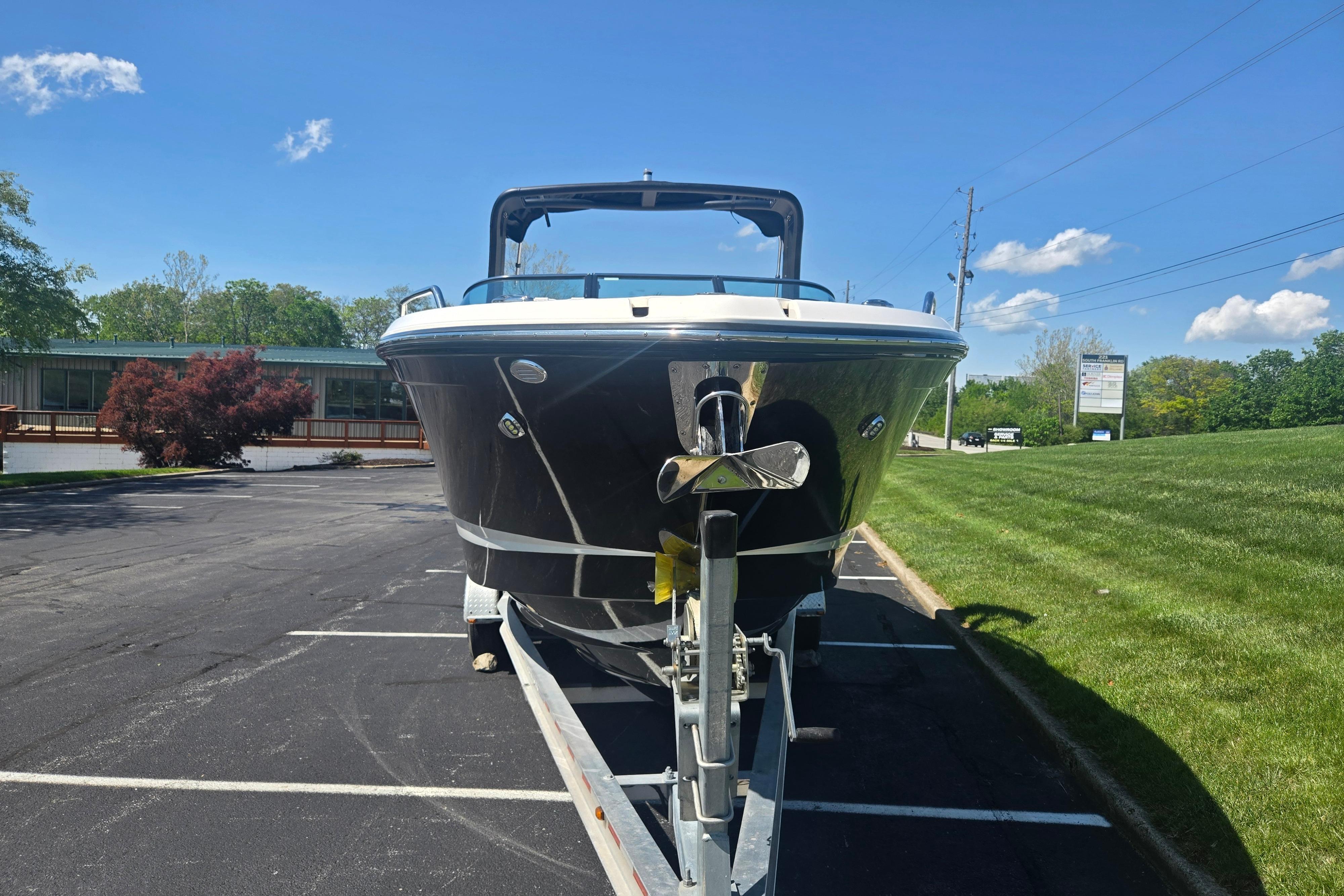 2018 Chaparral 267 SSX boat on trailer in parking lot, sunny day.