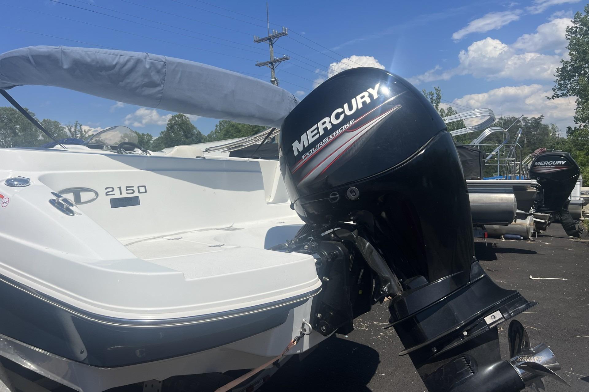 2017 Tahoe 2150 boat with Mercury FourStroke engine, parked outdoors under a clear blue sky.