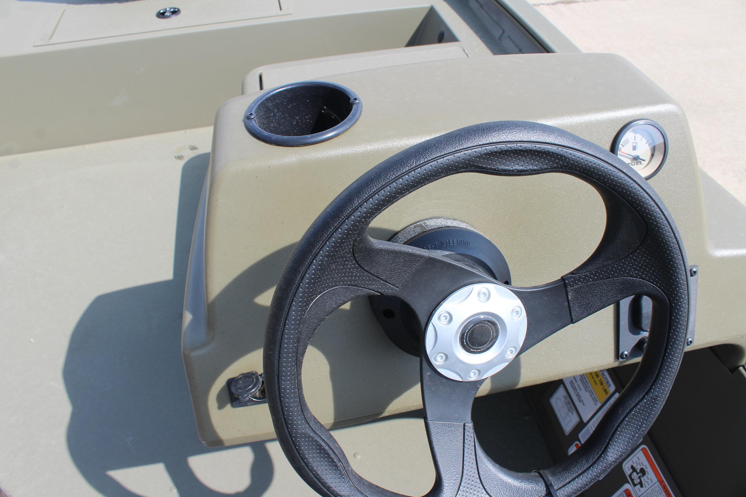 Steering console of 2026 Tracker Grizzly 1754 SC boat with cup holder and gauge.