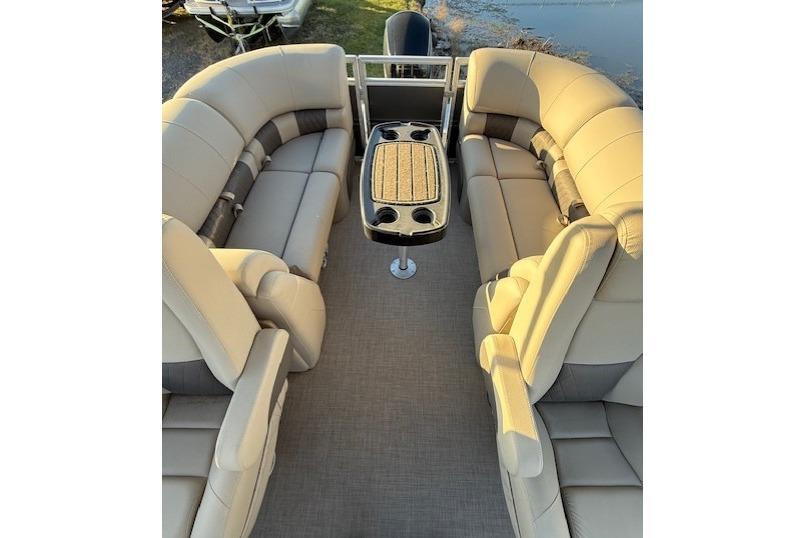2025 Sun Tracker Party Barge 22 XP3 interior with beige seating and central table.