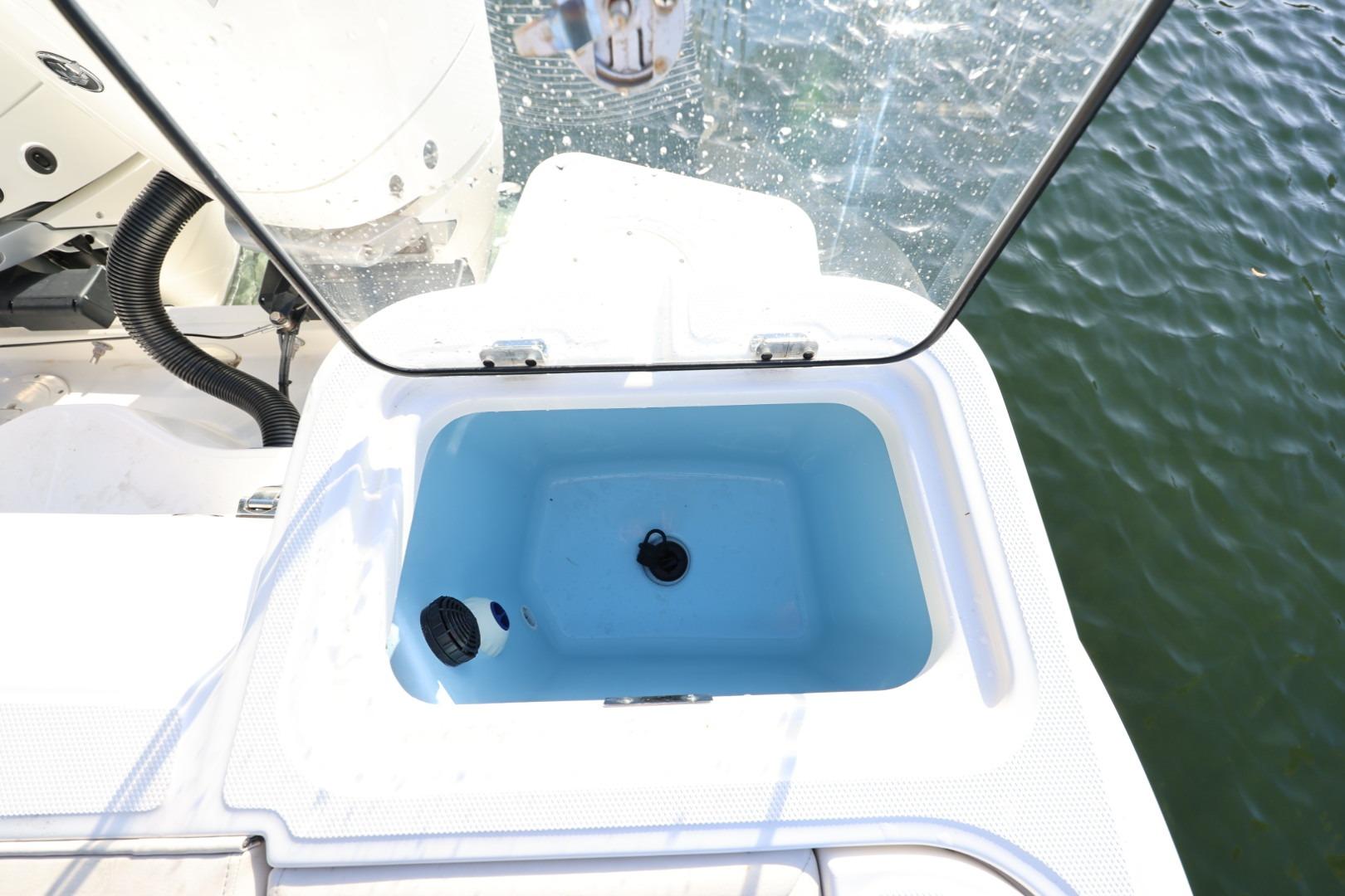 Livewell on 2025 Boston Whaler 325 Conquest boat, open lid, near water.