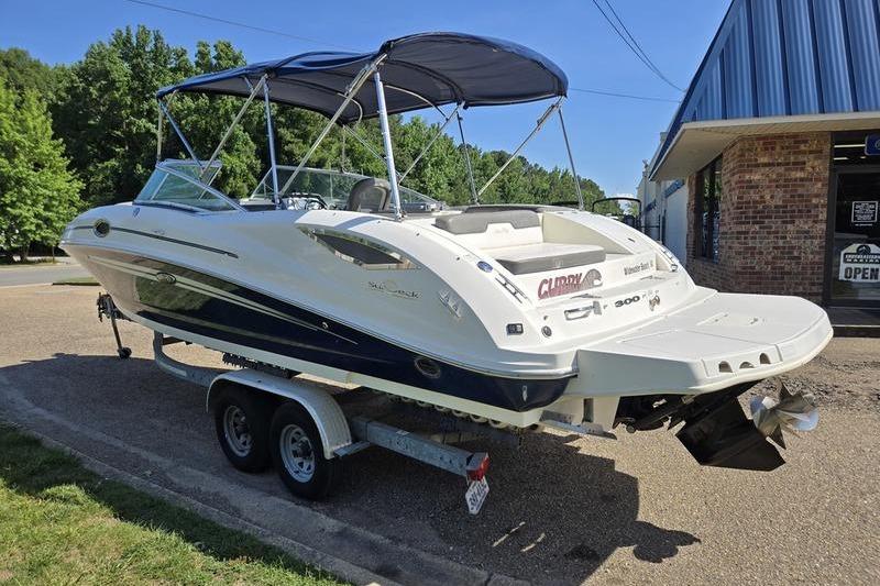 2011 Sea Ray 300 Sundeck boat on trailer, parked outside a building.