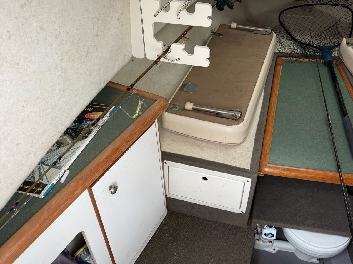 Interior of a 2001 Trophy 2509 Walkaround with fishing rods and storage space.