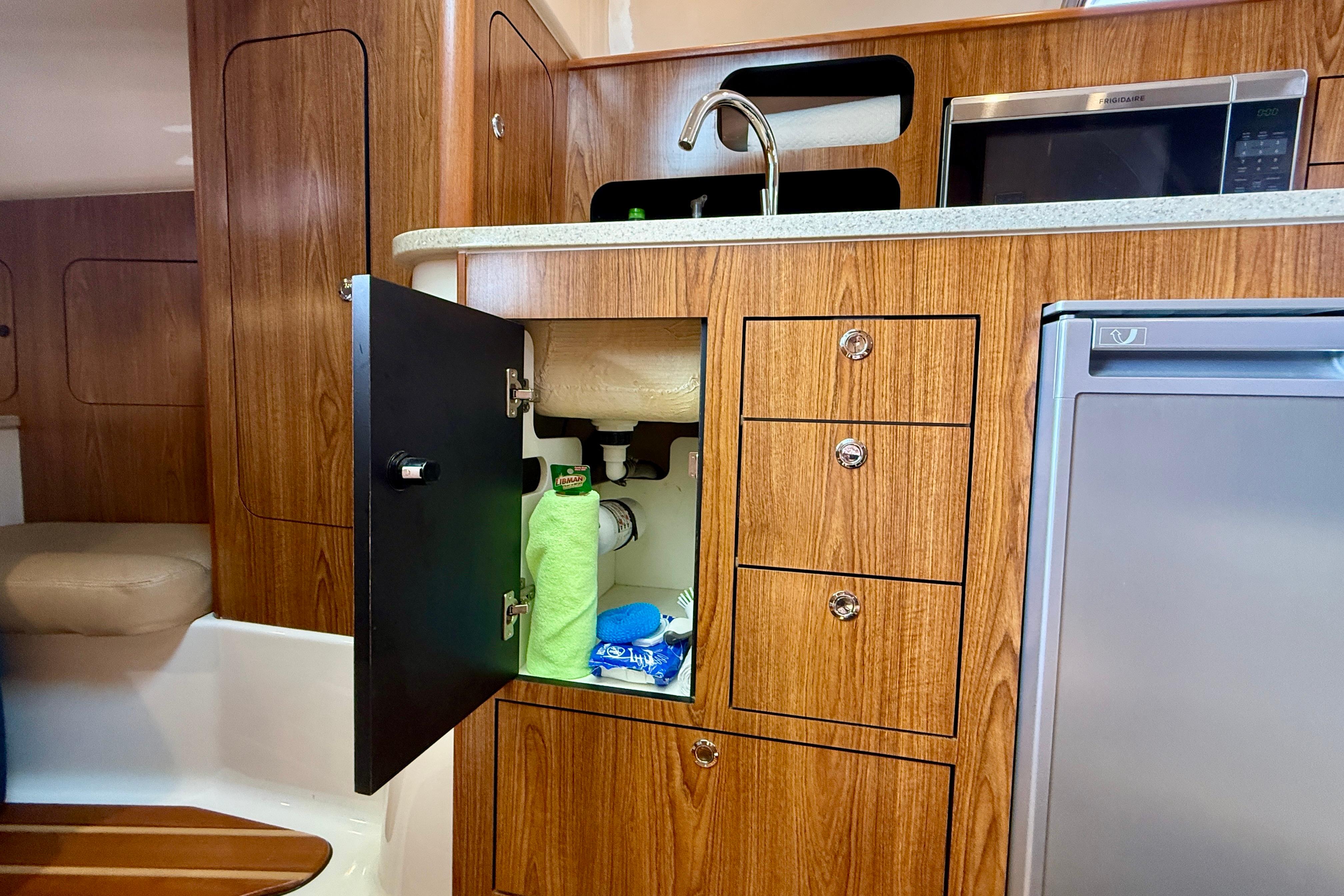 2012 Pursuit OS 345 Offshore boat interior with wooden cabinetry and open storage.