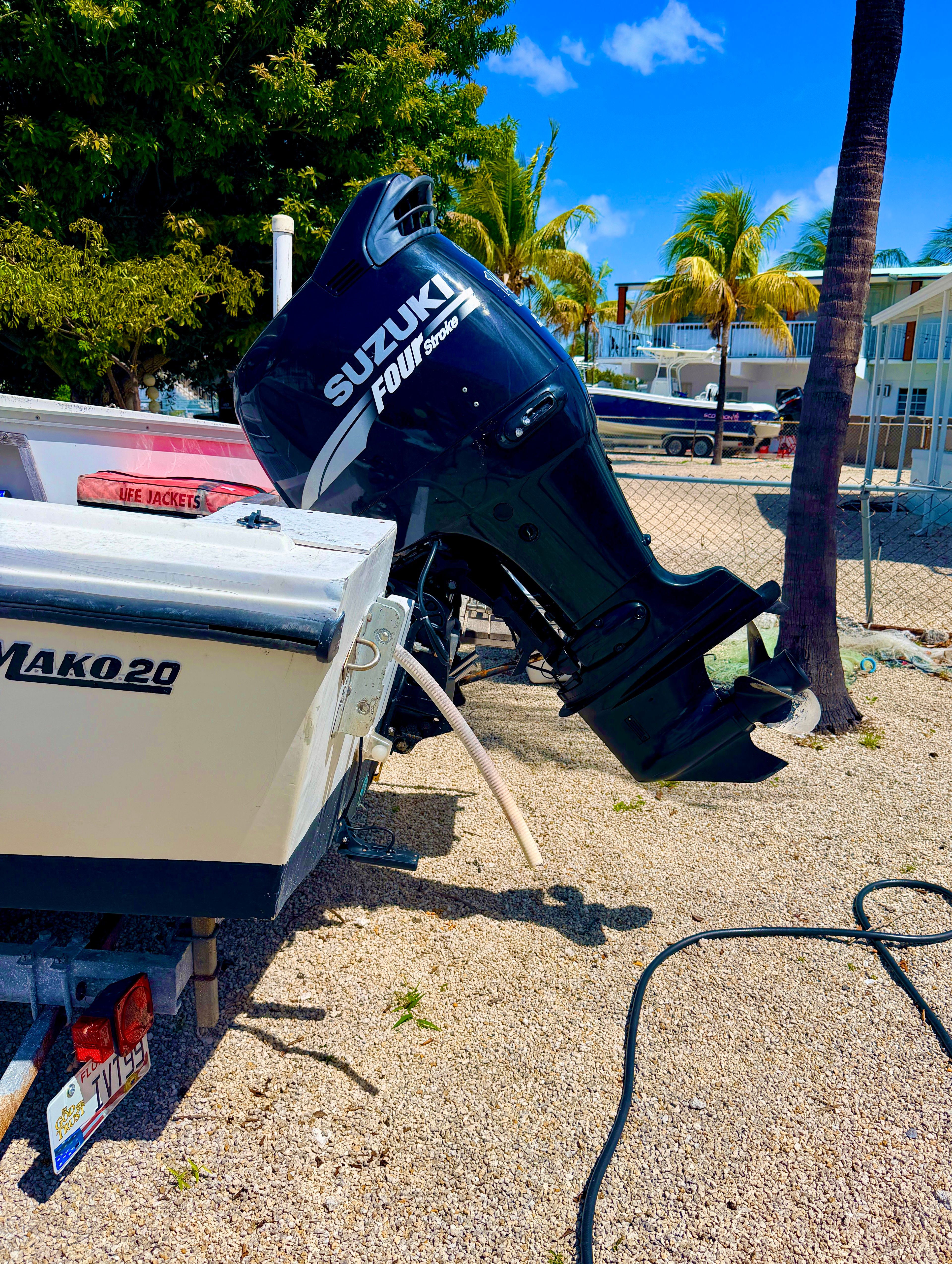 1970 Mako 20 boat with Suzuki outboard motor, parked on gravel.