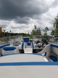 2004 Mariah SK-10 boat interior with blue and white seating under cloudy skies.