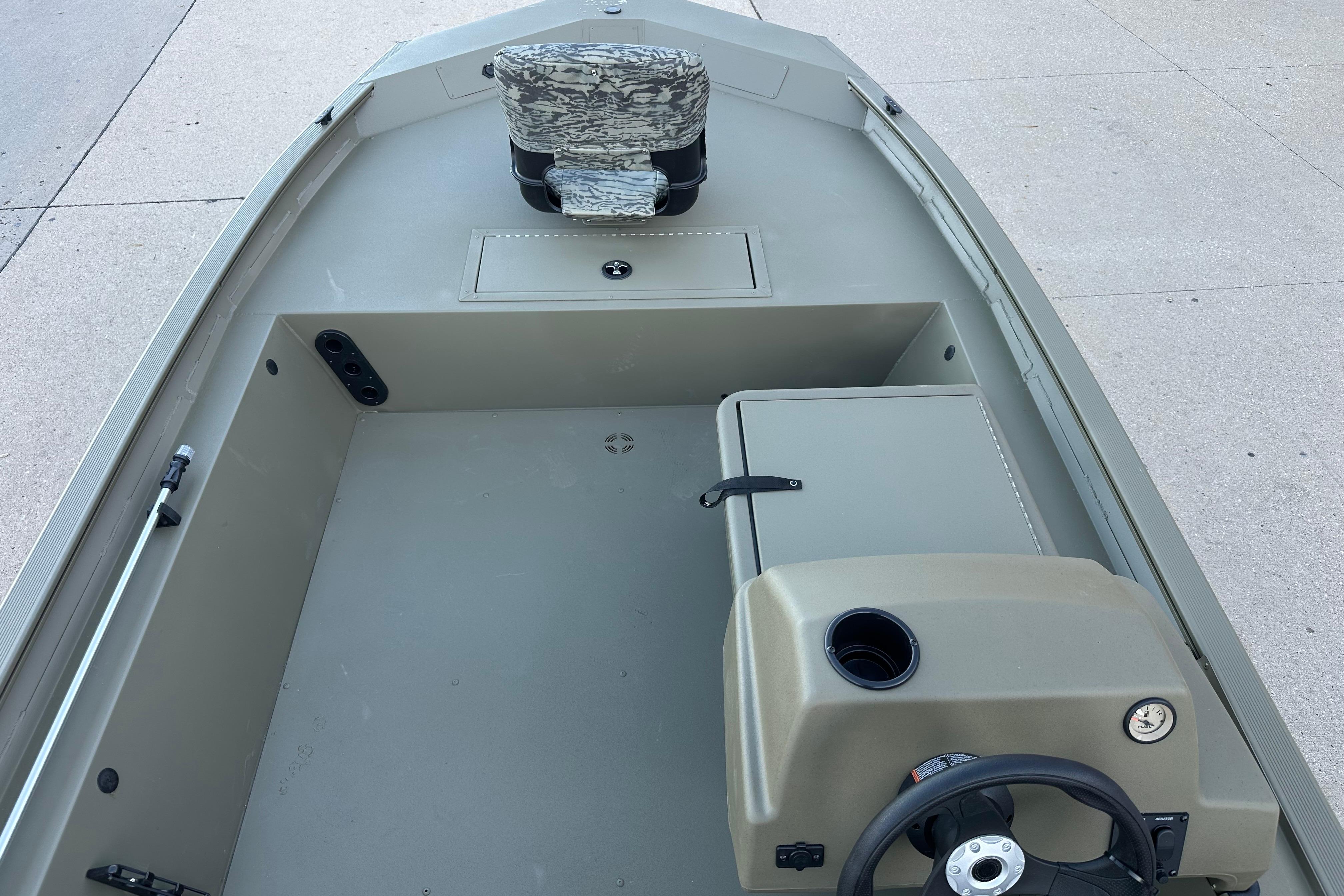 2026 Tracker Grizzly 1754 SC boat interior with steering console and camo seat.