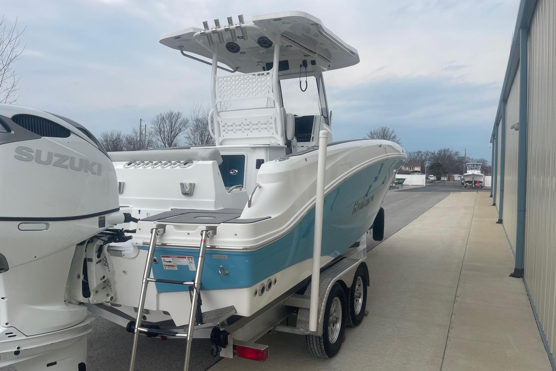 2025 Hurricane Center Console 24 OB boat with Suzuki engine on trailer, parked outdoors.