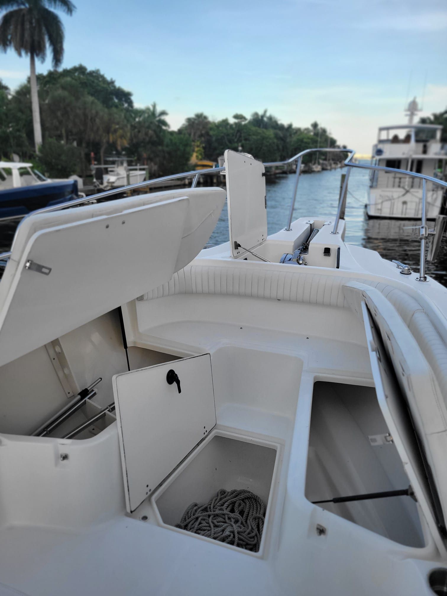 Boston Whaler 26 Outrage 2001 with open storage hatch by the water.