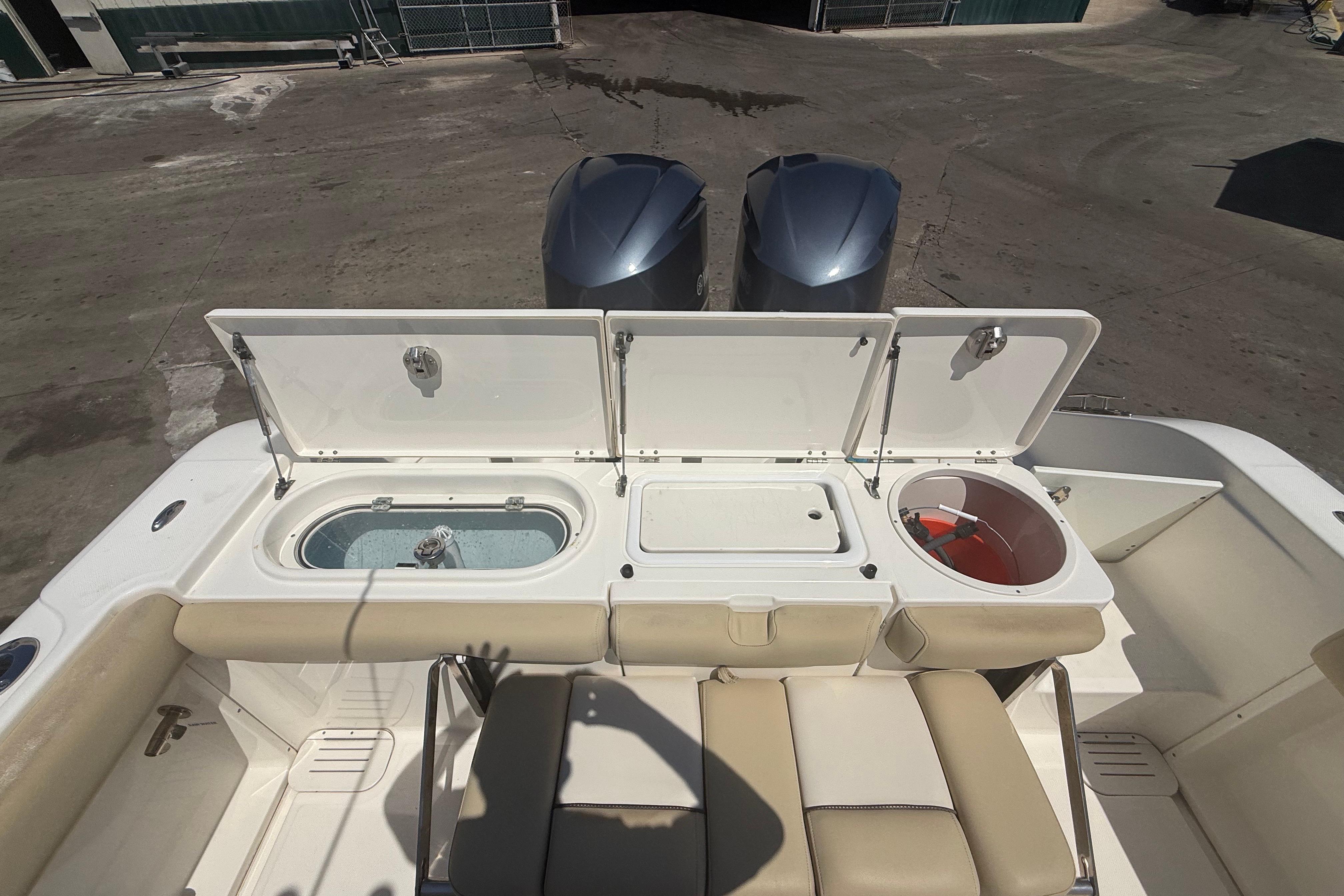 2019 Key West Billistic 281 Center Console boat with open storage compartments and twin engines.