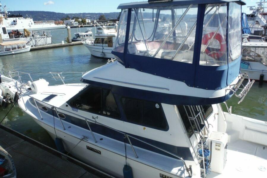 1990 Mediterranean Sport Fish boat docked at a marina, featuring a blue and white design.
