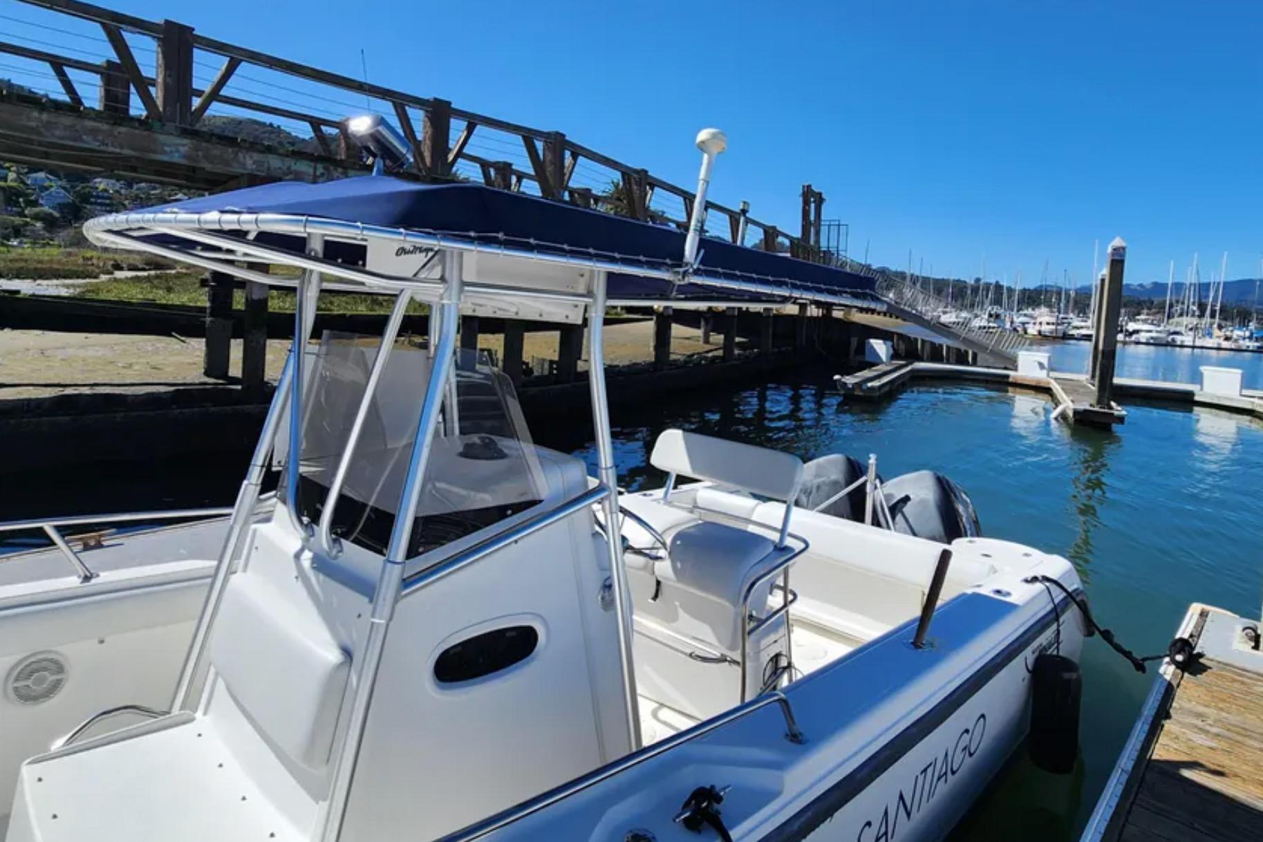 2001 Boston Whaler 26 Outrage docked at marina under clear blue sky.