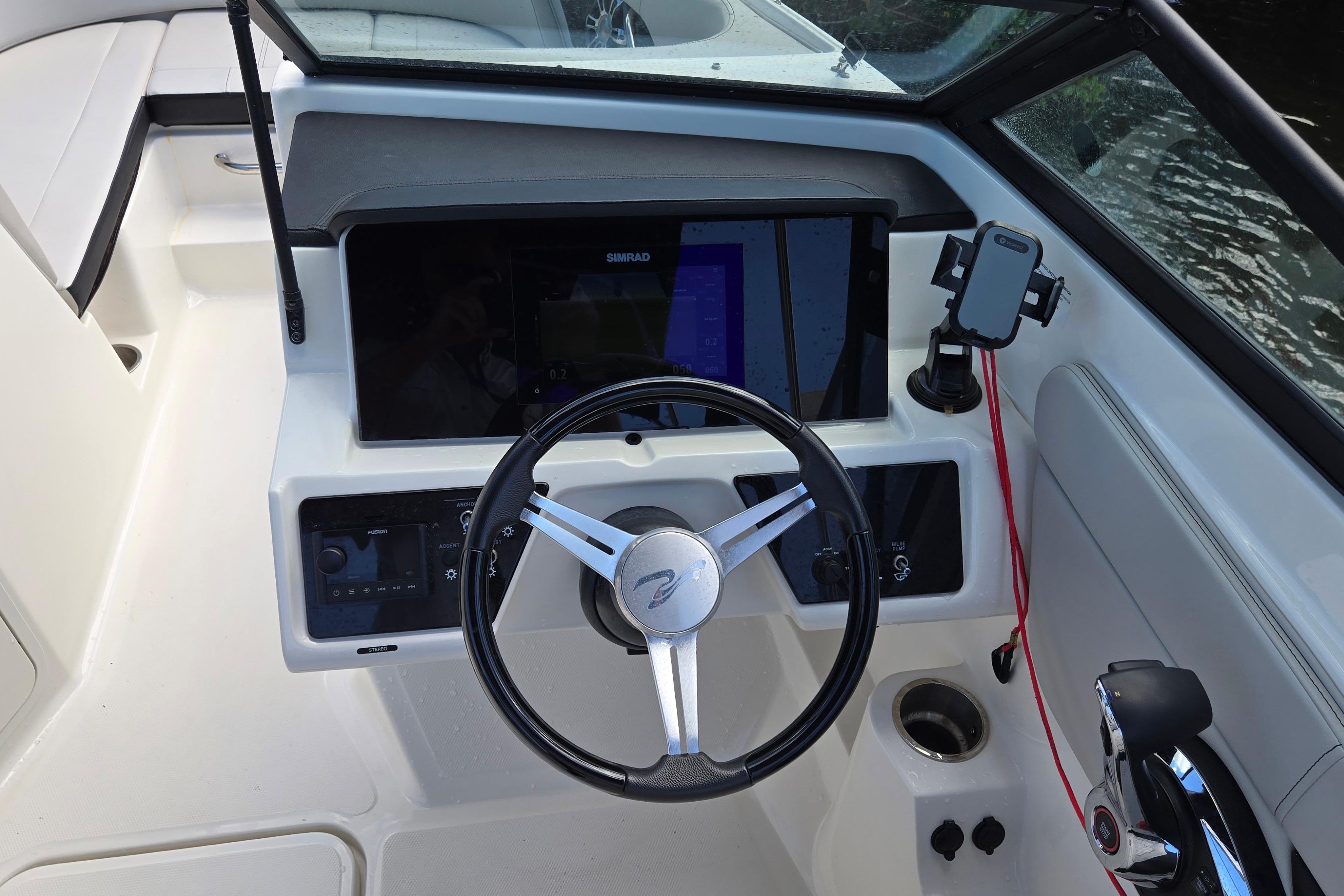 2023 Sea Ray SPX 210 boat dashboard with steering wheel and navigation controls.